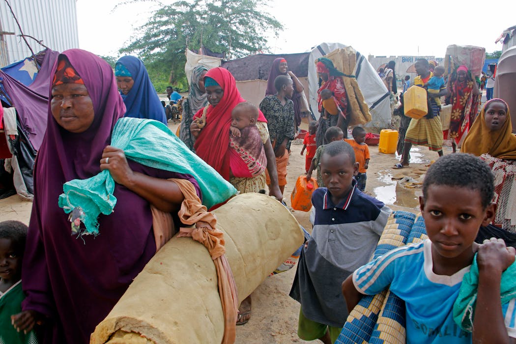 Somali displaced people vacate their camp after heavy floods entered their makeshift shelter, in Mogadishu, Somalia, Monday, Nov, 13, 2023. Somali authorities say floods caused by torrential rainfall have killed at least 30 people in various parts of the country. 