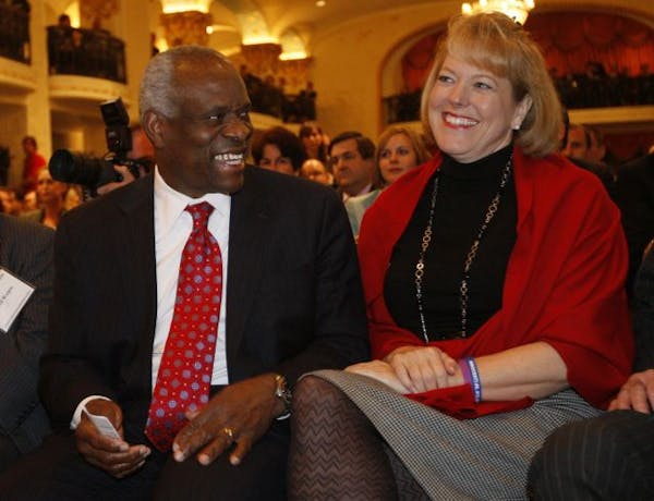 FILE - In this Nov. 15, 2007, photo, Supreme Court Justice Clarence Thomas, left, sits with his wife Virginia Thomas, as he is introduced at the Feder