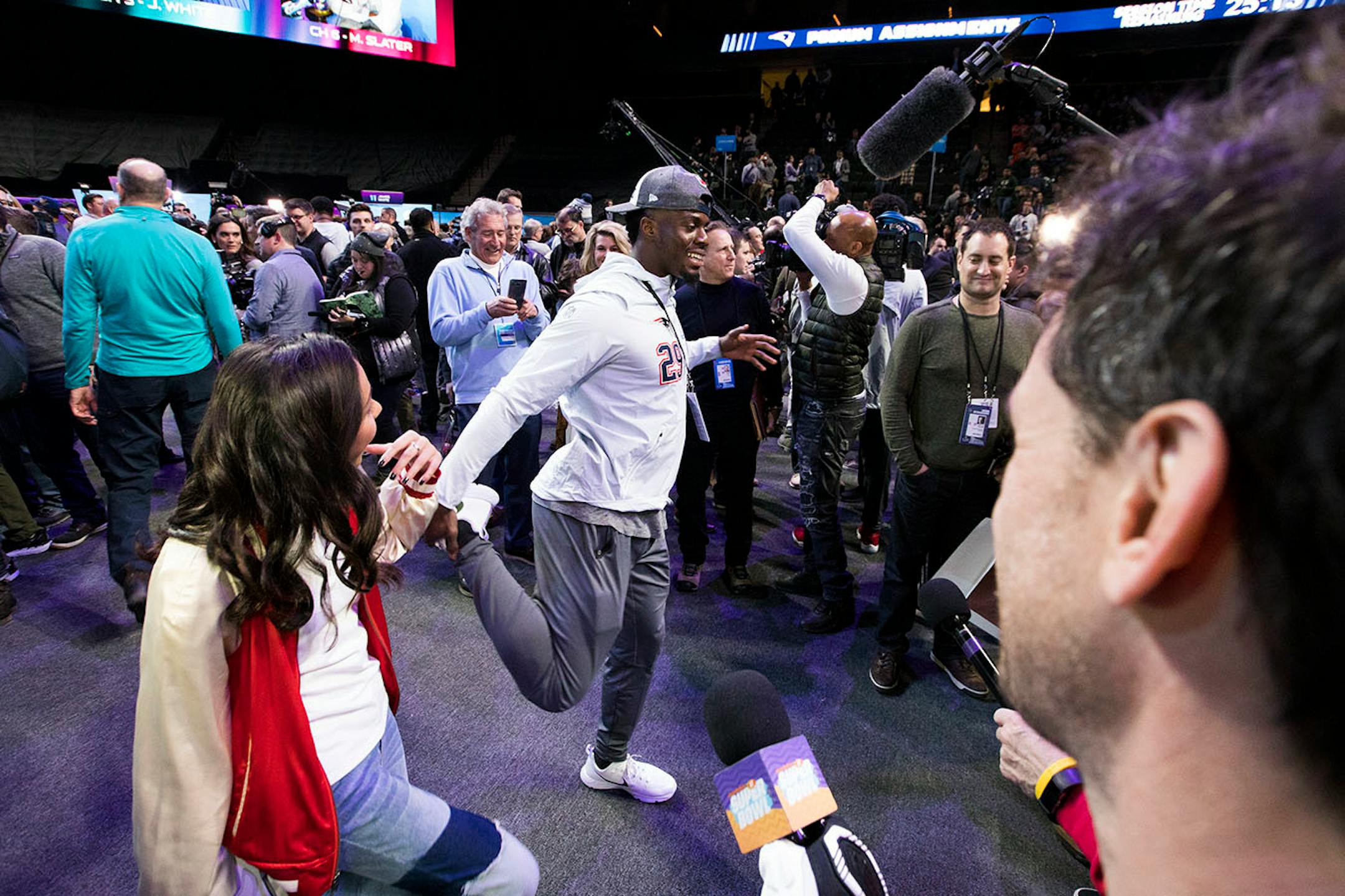 Patriots player Johnson Bademosi shows off some stretching moves during an interview.