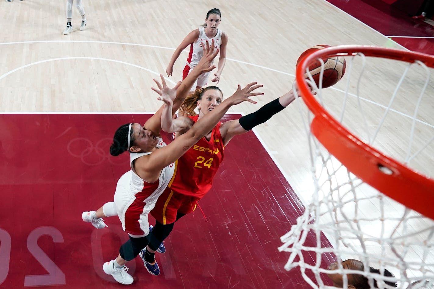 Spain's Laura Gil drives to the basket ahead of Canada's Natalie Achonwa, left, during a women's basketball preliminary round game