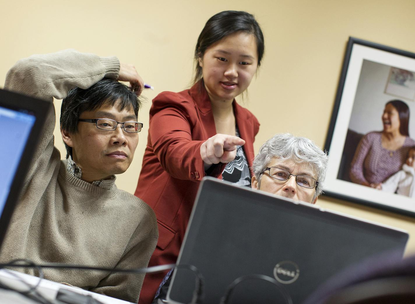 Navigator Nou Chee Lee, center, helps Taichi Chen, left, and Robin Chen of New Hope sign up for MNsure health benefits before the Dec. 23 deadline for Jan. 1 coverage at Portico in St. Paul December 21, 2013. (Courtney Perry/Special to the Star Tribune)