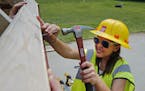 Girl Scout Maddie Olafson nailed down siding on one of the tiny houses under construction at Camp Lakamaga in Marine on St. Croix on Saturday.