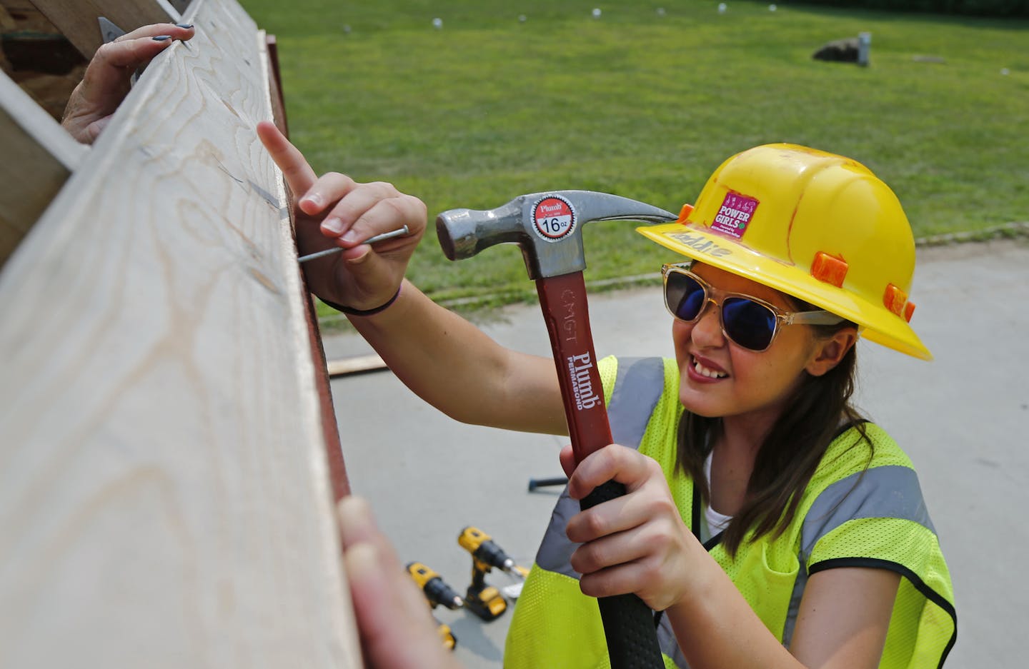 Girl Scout Maddie Olafson nailed down siding on one of the tiny houses under construction at Camp Lakamaga in Marine on St. Croix on Saturday.