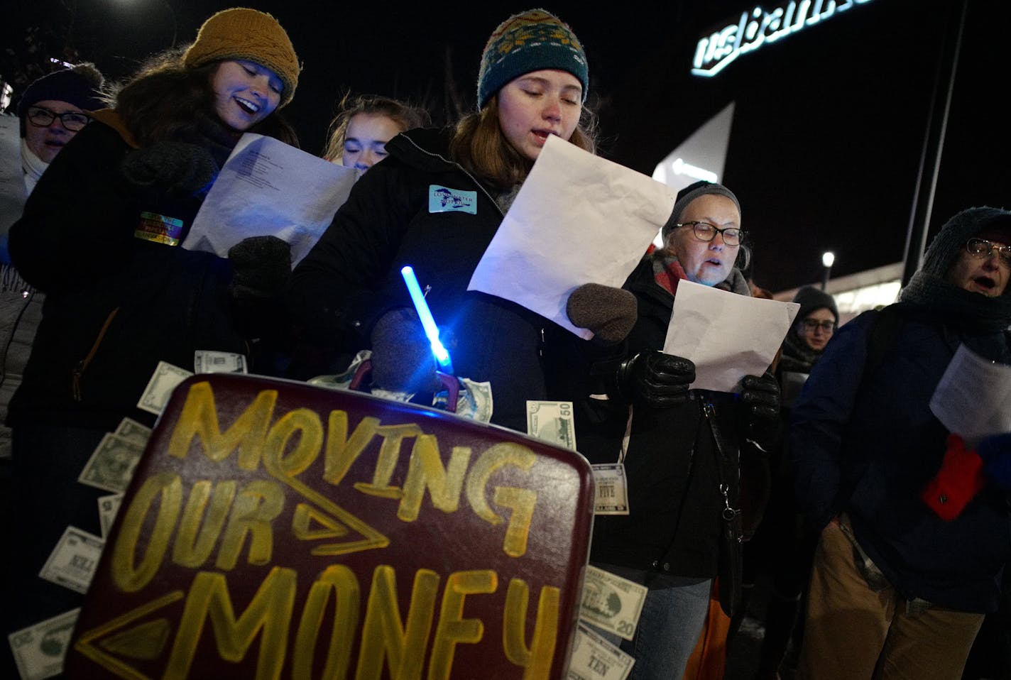 Dakota Access Pipeline (DAPL) protesters including Margaret Breen, a student at Macalester College, with suitcase, sang anti-US Bank Stadium Christmas carols a bank employees arrived for a holiday function.