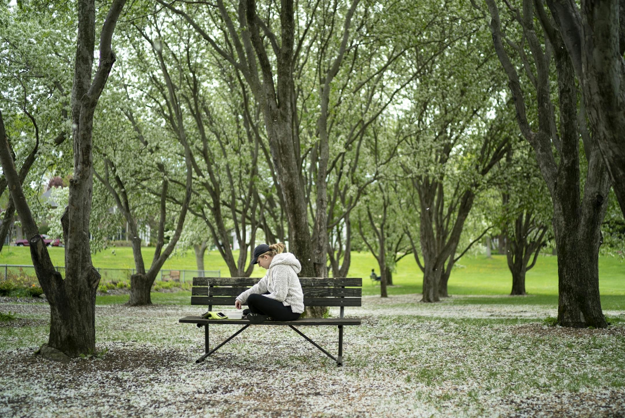 Carly Madden,18, had her lunch on a bench in a crabapple tree grove next to the Rose Garden at Lake Harriet in Minneapolis, Minn., on Tuesday, May 21, 2019.