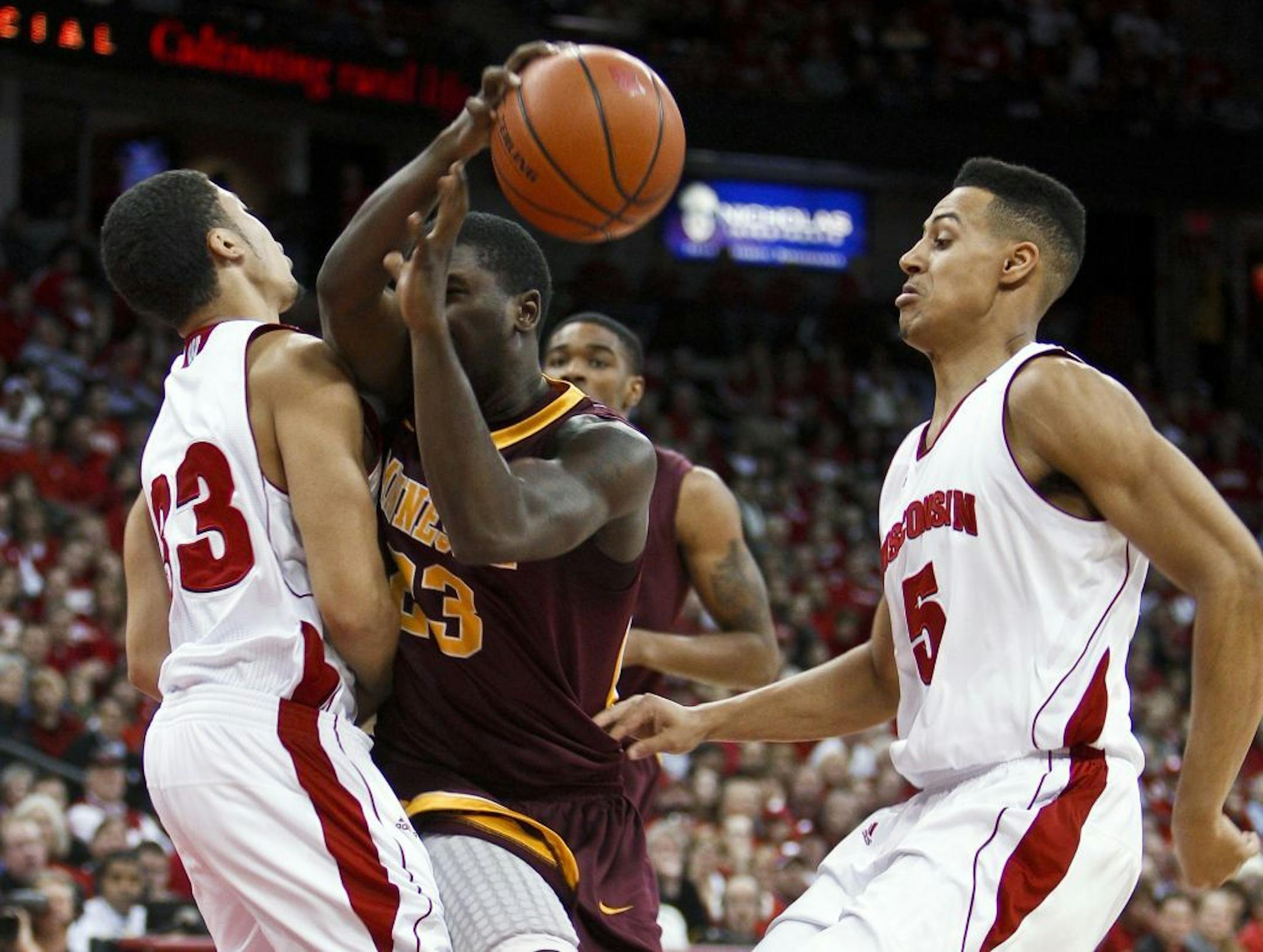 The Gophers' Chip Armelin, center, was fouled by Wisconsin's Rob Wilson, left, during the first half of the Badgers' 52-45 victory Tuesday night.