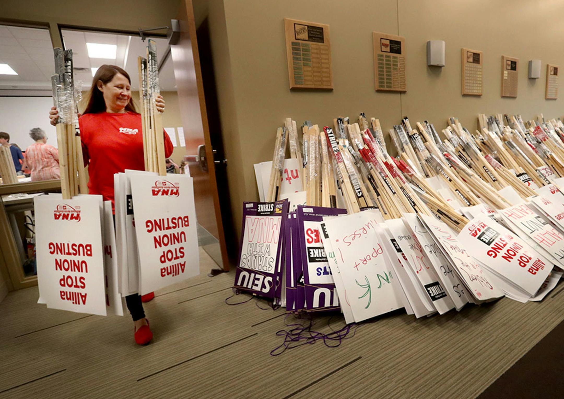 Valerie Johnson, an RN at Abbott Northwestern Hospital, added to the pile as MNA nurses, Minnesota Nurses Association employees and family members joined forces at the MNA headquarters to make posters for picketing Saturday, June 18, 2016, should a strike happen Sunday at five Twin Cities Allina Health facilities. Cooper' mother Shannon Cunningham is a MNA employee.