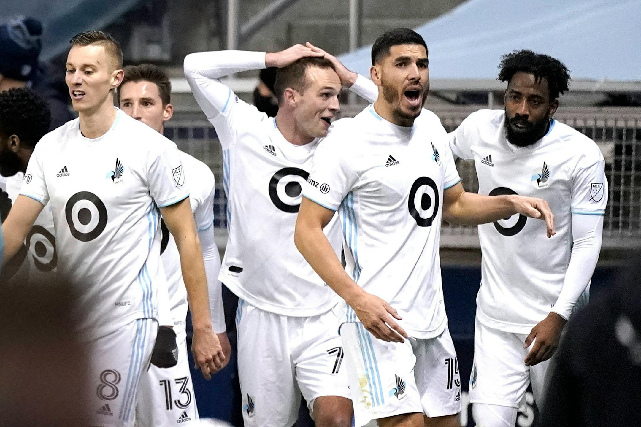 Minnesota United players celebrate after a goal by Kevin Molino, not pictured, during the first half of the team's MLS soccer match against Sporting Kansas City on Thursday, Dec. 3, 2020, Kansas City, Kan. (AP Photo/Charlie Riedel)