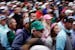 Spectators leave the Augusta National Golf Course after play was suspended because of approaching inclement during a practice round for the Masters on