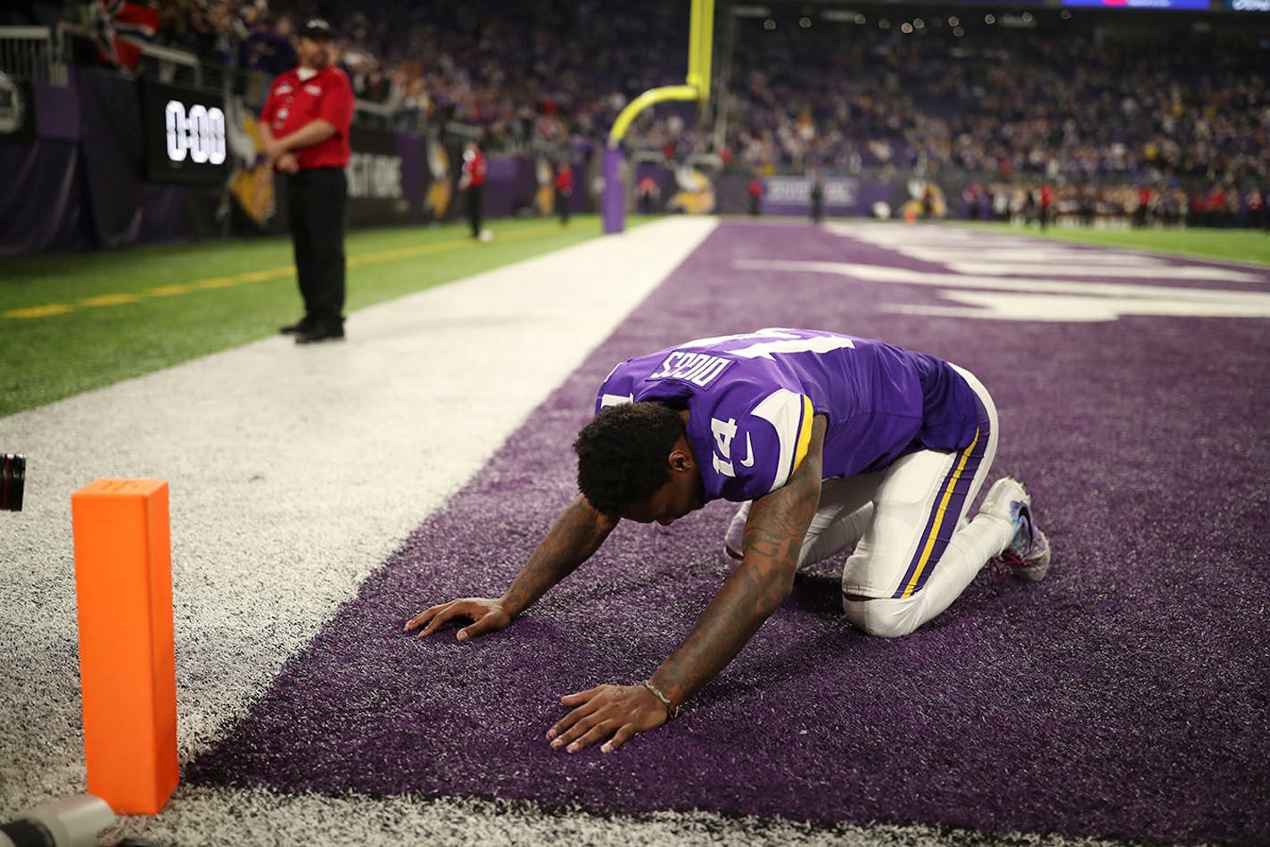 After tossing aside his helmet, Vikings receiver Stefon Diggs kneeled in the end zone after making his 61-yard game-winning touchdown on the last play of Sunday's NFC divisional playoff.