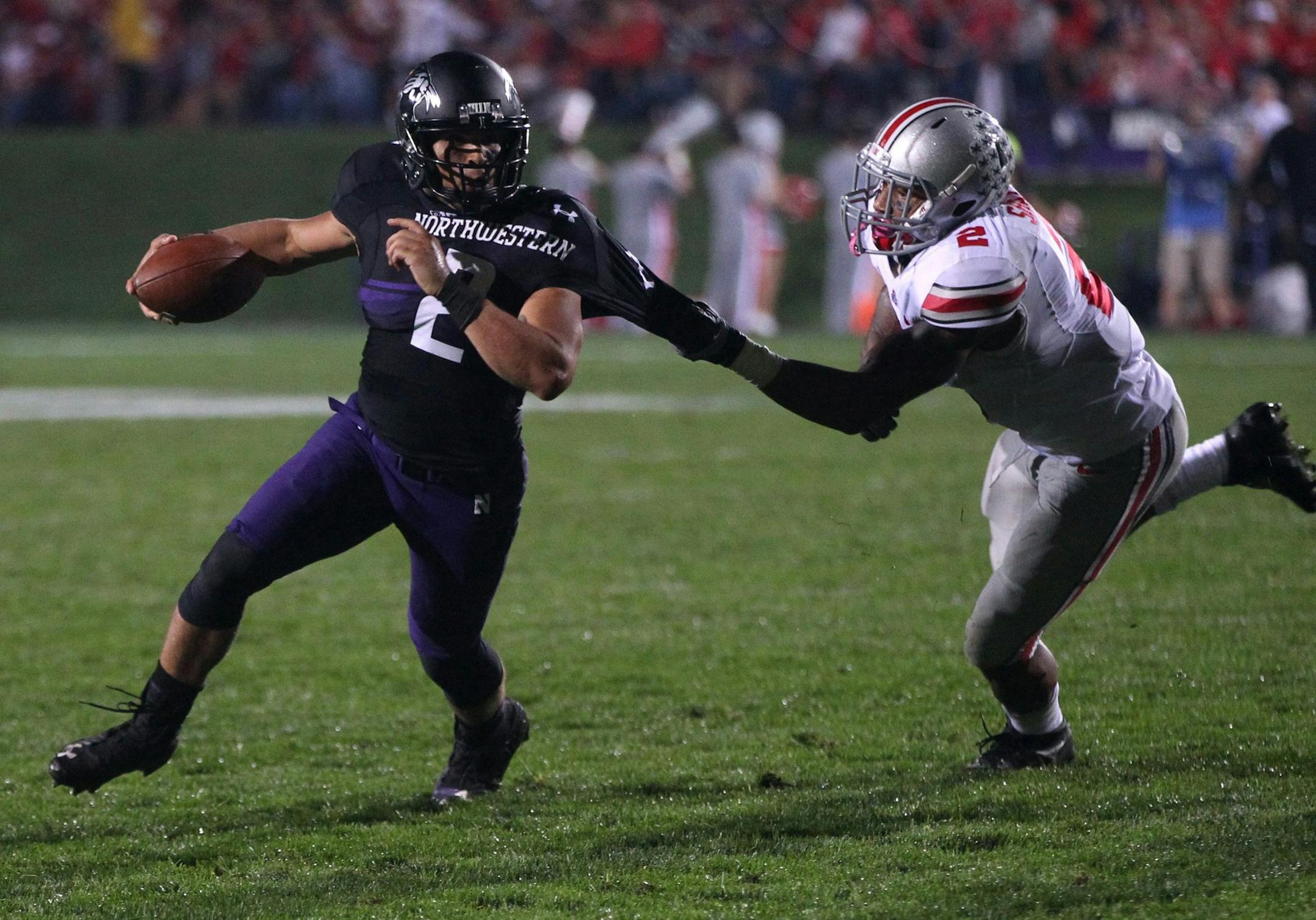 Northwestern quarterback Kain Colter, left, tries to elude the tackle of Ohio State safety Christian Bryant in the second quarter at Ryan Field in Evanston, Illinois, on Saturday, October 5, 2013. (Chris Sweda/Chicago Tribune/MCT) ORG XMIT: 1144066 ORG XMIT: MIN1310052229431856