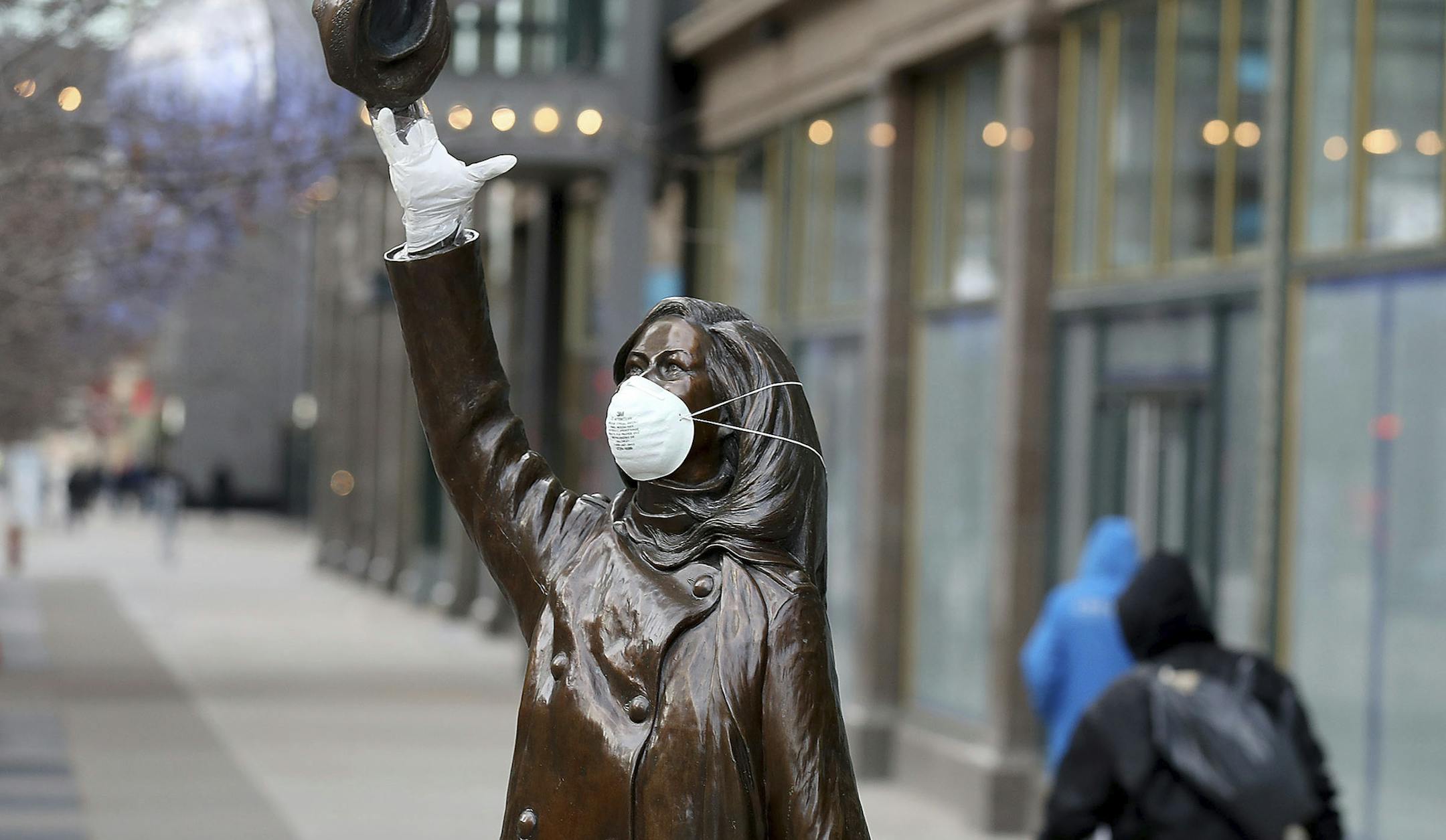 The Mary Tyler Moore statue on Nicollet Mall got a mask and rubber glove, perhaps for levity in the face of the Coronavirus, and seen Wednesday, April 1, 2020, in downtown Minneapolis. (David Joles/Star Tribune via AP)
