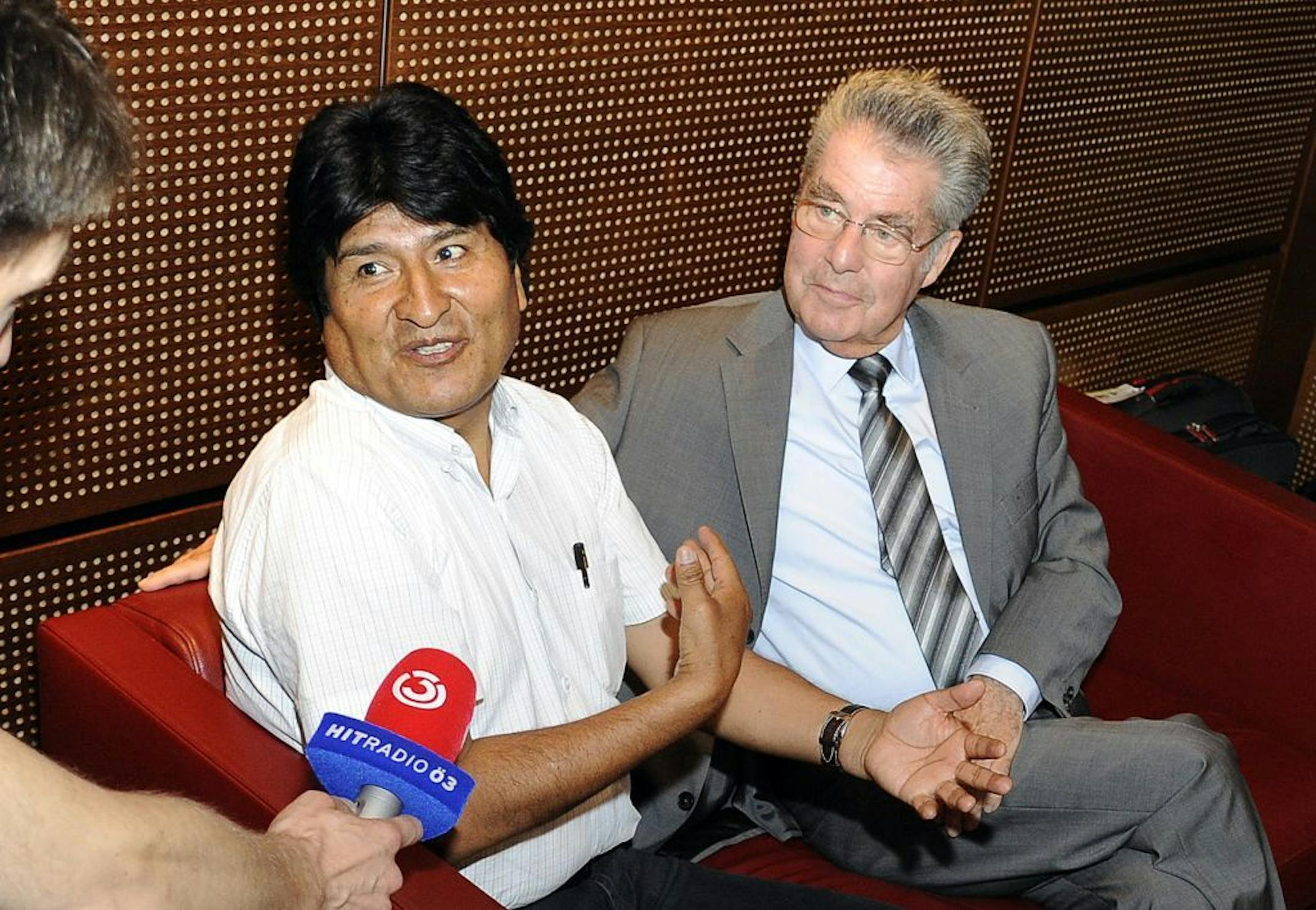 Bolivia's President Evo Morales, left, talks to reporters as he sits next to Austrian President Heinz Fischer at Vienna's Schwechat airport, Wednesday, July 3, 2013.