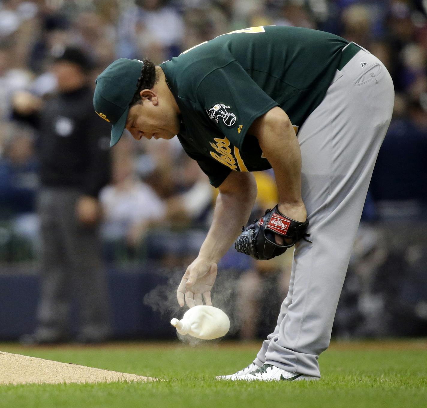 Oakland Athletics starting pitcher Bartolo Colon uses a rosin bag during the fifth inning of a baseball game against the Milwaukee Brewers Wednesday, June 5, 2013, in Milwaukee. (AP Photo/Morry Gash) ORG XMIT: MIN2013060801222335