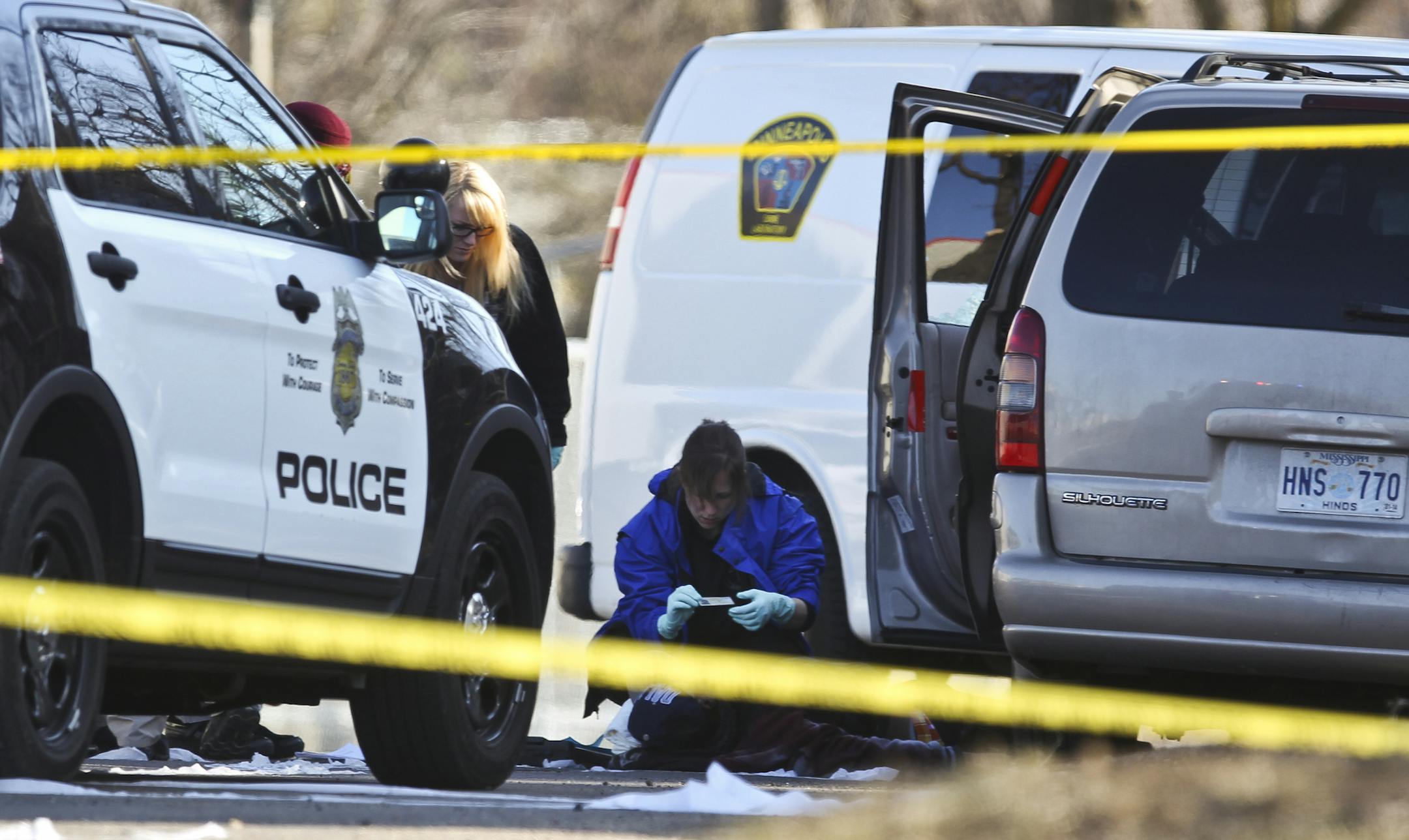 Medical examiners worked over the body of an adult male who was killed in a shooting on Humboldt Avenue North on Tuesday, April 2, 2013 in Minneapolis, Minn. ] (RENEE JONES SCHNEIDER * reneejones@startribune.com)