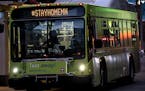 In this Monday, March 23, 2020, photo, Metro Transit busses travel with the hashtag #STAYHOMEMN during the coronavirus outbreak on Nicollet Mall in do