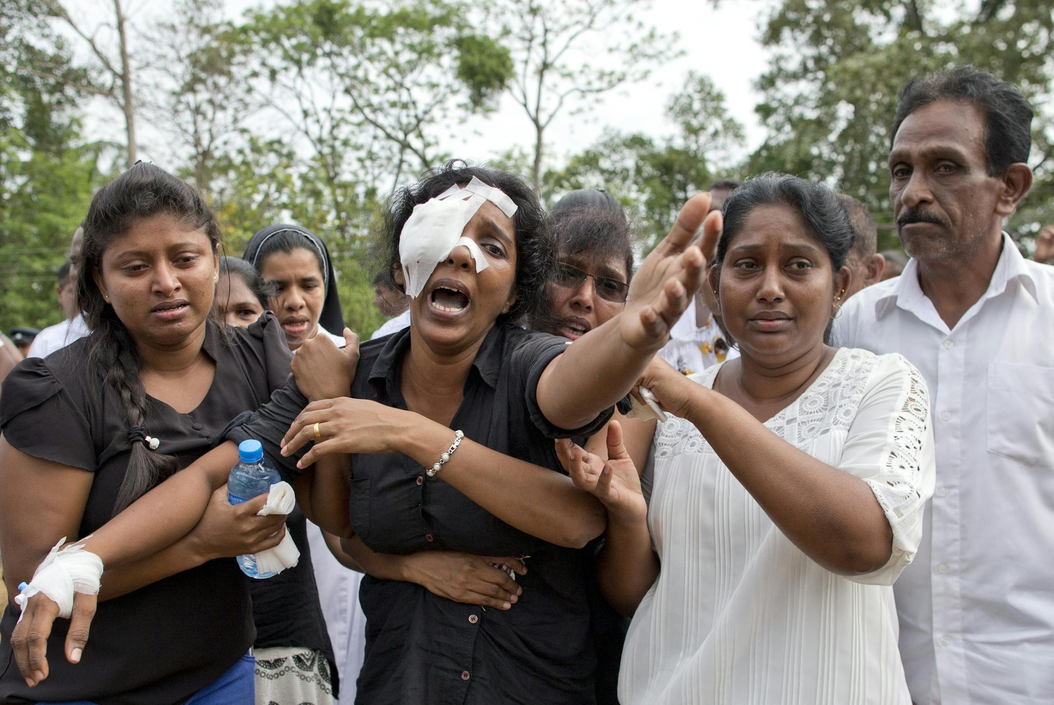Anusha Kumari, center, weeps during a mass burial for her husband, two children and three siblings, all victims of Easter Sunday's bomb attacks, in Negombo, Sri Lanka, Wednesday, April 24, 2019. In an instant on Easter Sunday, Kumari, 43, was left childless and a widow when suicide bombers launched a coordinated attack on churches and luxury hotels in and just outside Sri Lanka’s capital, Colombo. (AP Photo/Gemunu Amarasinghe)