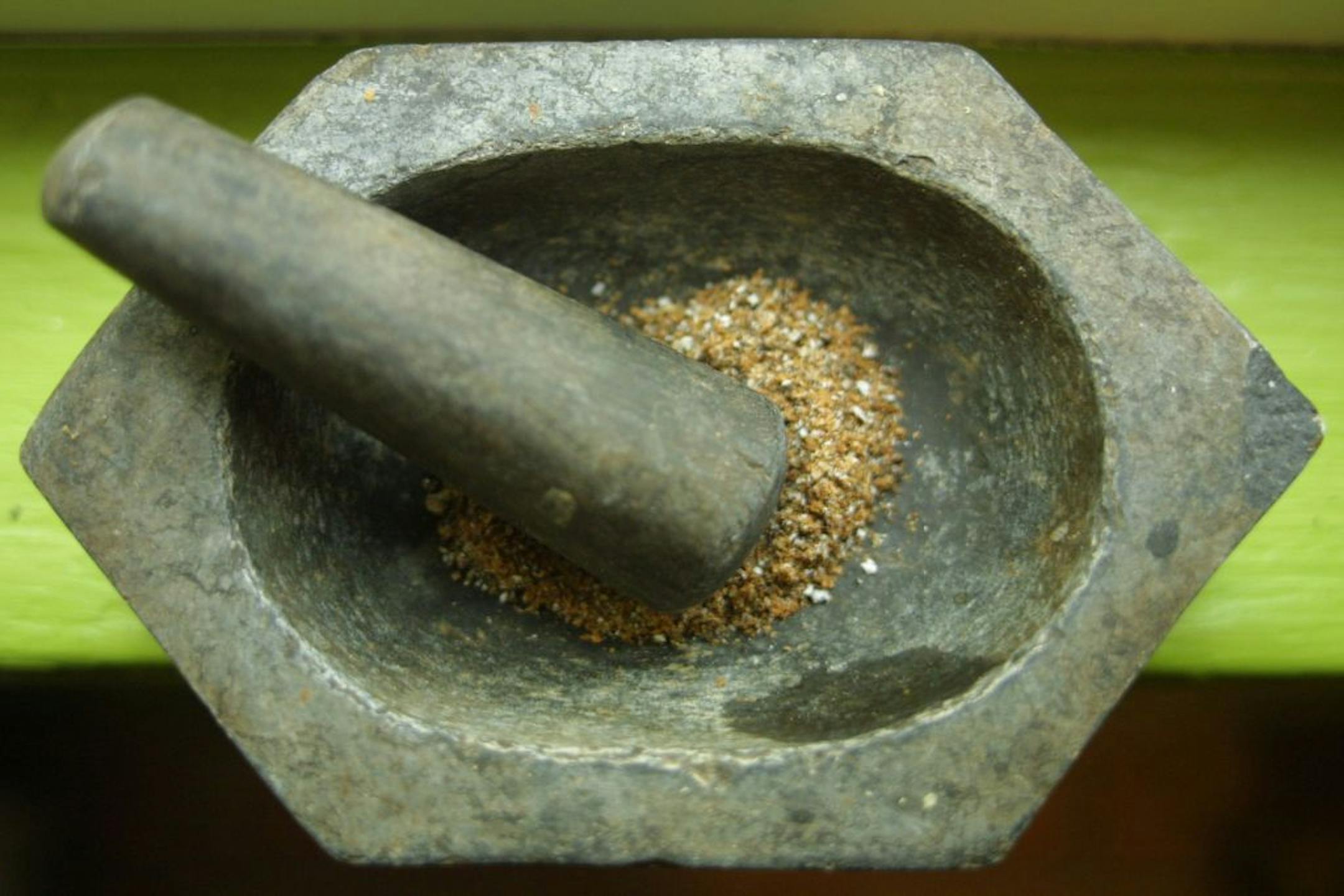 Iyer Raghaven in his living room in Minneapolis, MN published a cooking book with Betty Crocker on traditional Indian foods. The spices he uses include ground cumin seed that he has ground in an antique mortar and pedestal.