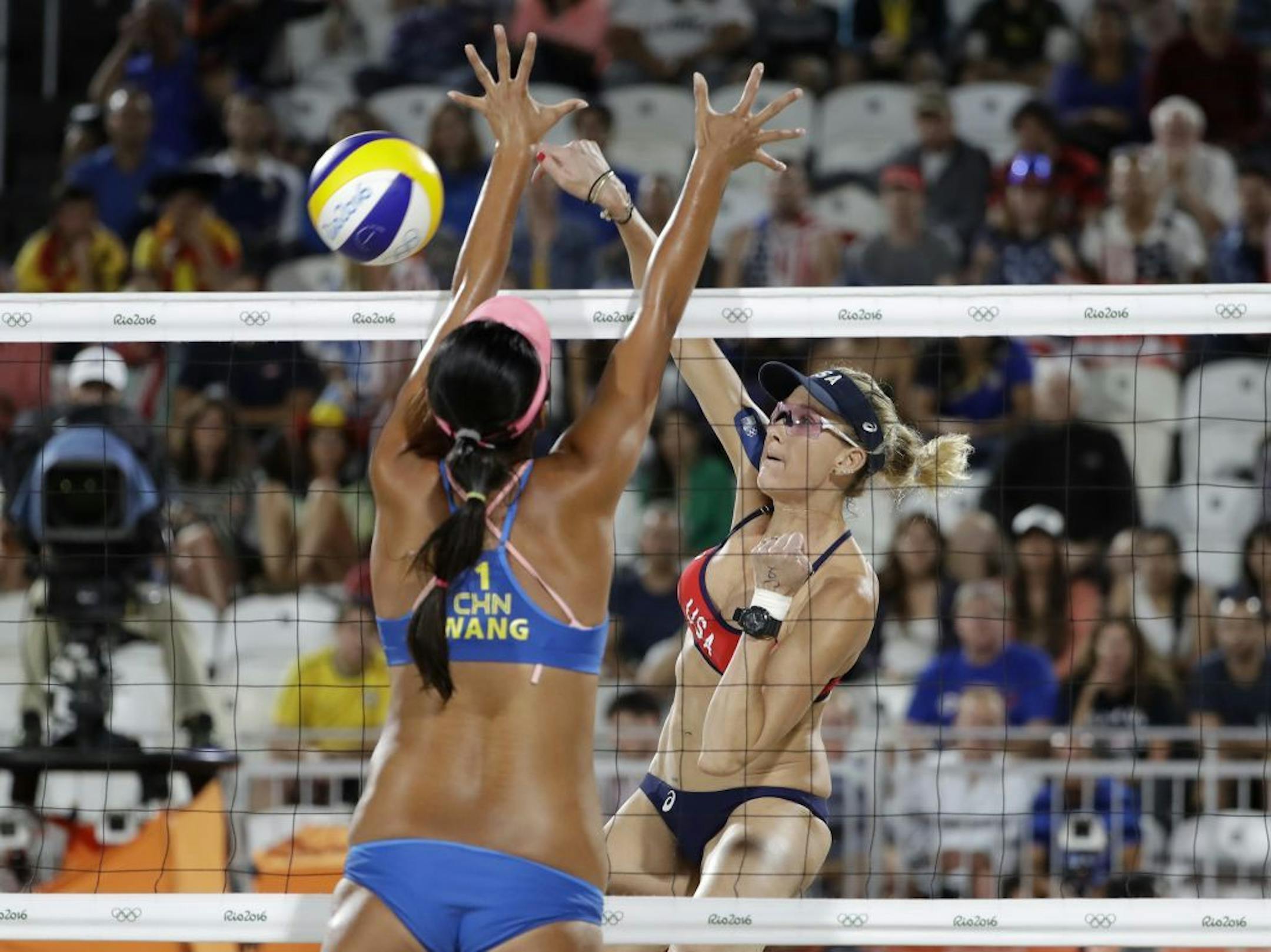 United States' Kerri Walsh Jennings, right, hits over China's Wang Fan during a women's beach volleyball match at the 2016 Summer Olympics in Rio de Janeiro, Brazil, Tuesday, Aug. 9, 2016.