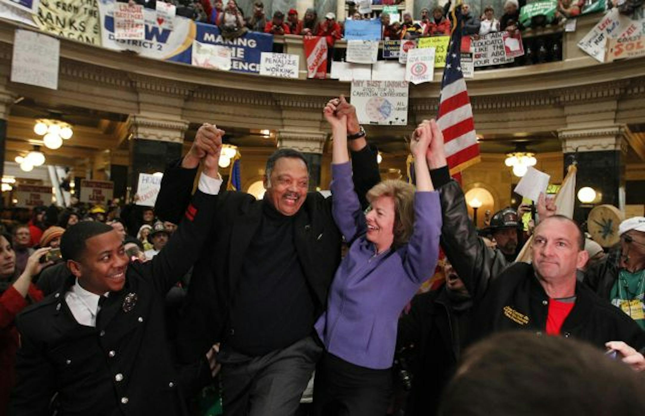 The Rev. Jesse Jackson and U.S. Rep. Tammy Baldwin, D-Wis., spoke to supporters of public union workers in the Wisconsin Capitol rotunda on Tuesday. Fourteen Senate Democrats have fled the state.