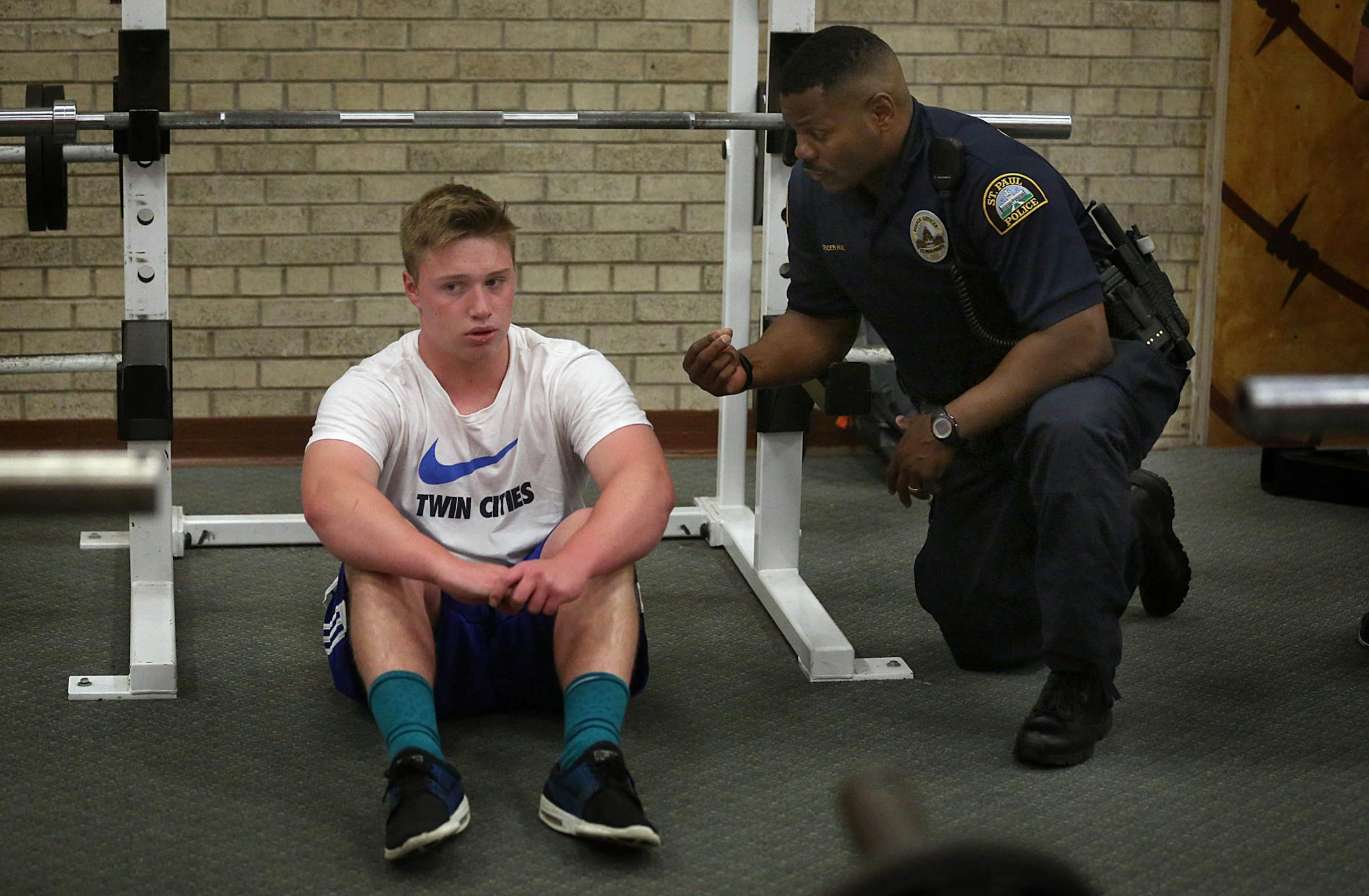 Cortez Hull, school resource officer (SRO) at Highland Park High School in St. Paul, talked with freshman Peyton Haider, 15, about weight lifting after school.