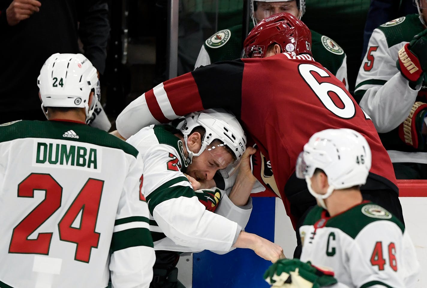 Minnesota Wild's Carson Soucy, center, fights with Arizona Coyotes' Lawson Crouse (67) during the first period of an NHL hockey game Tuesday, March 16, 2021, in St. Paul, Minn. Both players received penalties. (AP Photo/Hannah Foslien)