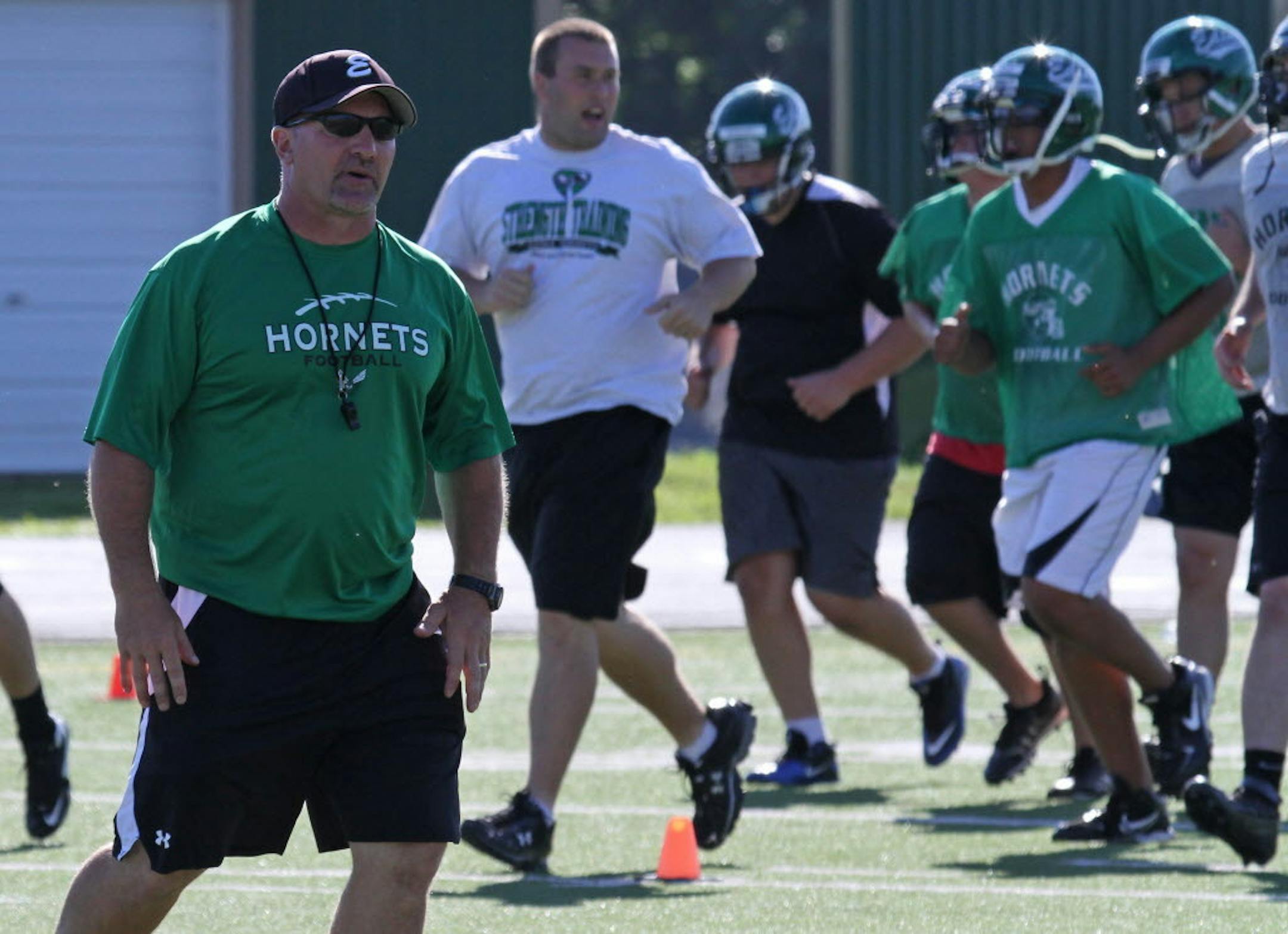 Edina football coach Reed Boltmann, left, ran drills with his team during a 2011 practice at the Edina Community Center. Botlmann resigned Thursday as head coach but will remain at the school as a teacher.