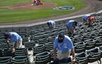 Ushers clean seats before a spring training baseball game between the Minnesota Twins and the Boston Red Sox in Fort Myers, Fla., Wednesday, March 2, 