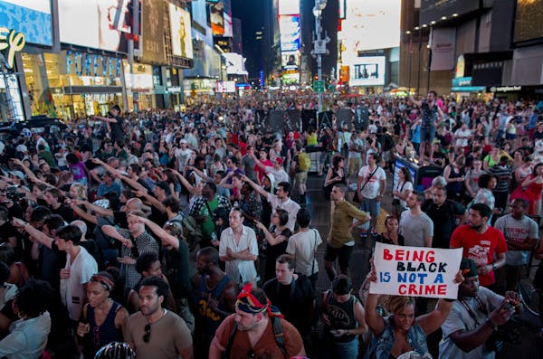 Throngs of marches gather in Times Square, Sunday, in New York, for a protest against the acquittal of volunteer neighborhood watch member George Zimm