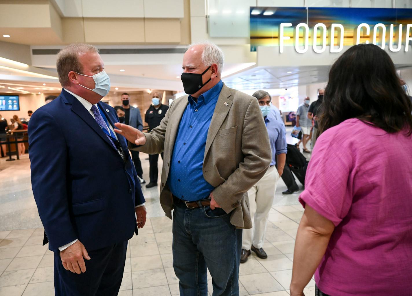Minnesota Gov. Tim Walz, center, spoke with Rick King, chair of the Metropolitan Airport Commission, before Tuesday afternoon's press conference about pop-up community vaccination sites.