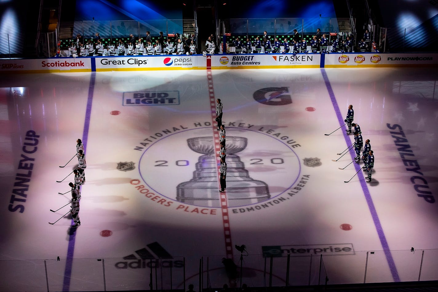 The Canucks and Wild stand for the national anthems before Game 1 of the series in Edmonton.