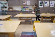 Duluth schools are among those switching to distance learning. In this photo from September, Sophie Gray Spehar disinfected each table in her art clas