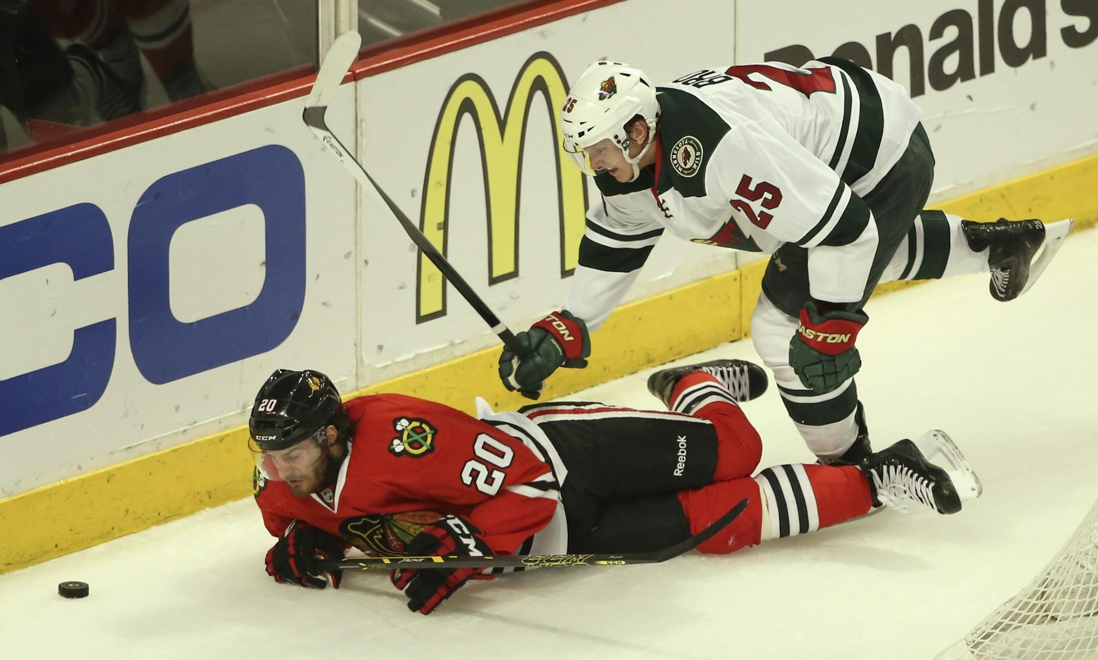 Minnesota Wild defenseman Jonas Brodin (25) knocks Chicago Blackhawks left wing Brandon Saad (20)to the ice during the first period of their game Sunday night at United Center in Chicago.