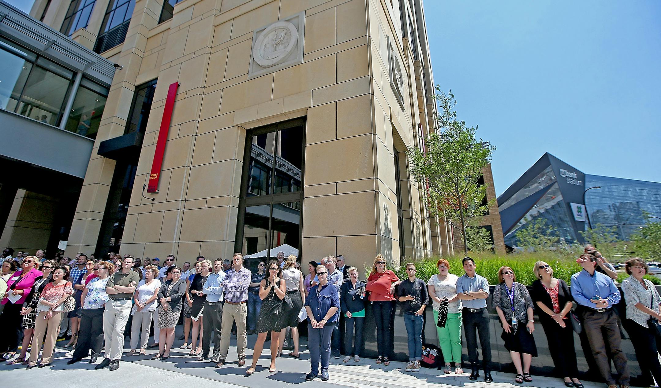 With the historic Star Tribune medallions decorating the exterior of the new Wells Fargo building, employees and visitors watched as executives and city officials celebrated the grand opening of Minneapolis East Town Towers, Wednesday, July 20, 2016 in downtown Minneapolis, MN.