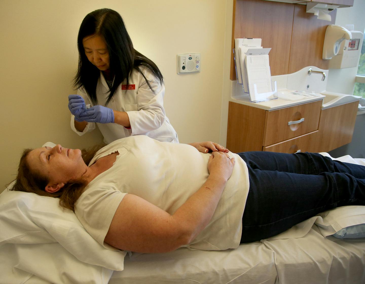 Lixin Qin applied the needles to patient Ellen Harrity during her treatment session. ] (KYNDELL HARKNESS/STAR TRIBUNE) kyndell.harkness@startribune.com Acupuncture at the Women's center at Methodist Hospital in St Louis Park., Thursday September 24, 2015.