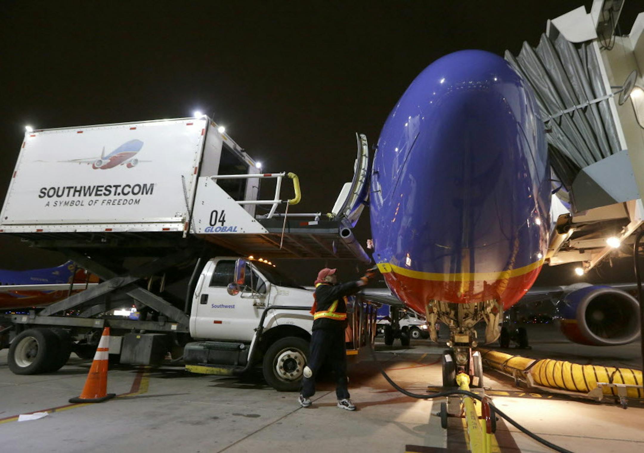 In this Nov. 13, 2014 photo, Southwest Airlines ground crewman Mike Shafer pulls the gate cable from an originator flight at Love Field in Dallas. Throughout the airline industry, the first flight of the day sets the tone for keeping the system's flights running on-time. (AP Photo/LM Otero)