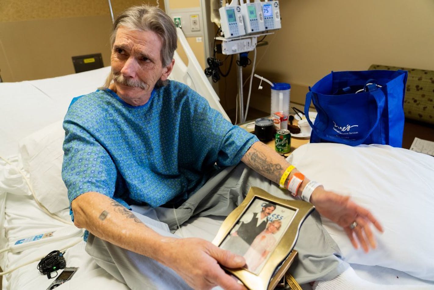 Mitchell holds a photo of his wife Kathy taken soon after their wedding. He said they made a pinky swear never to leave each other behind.