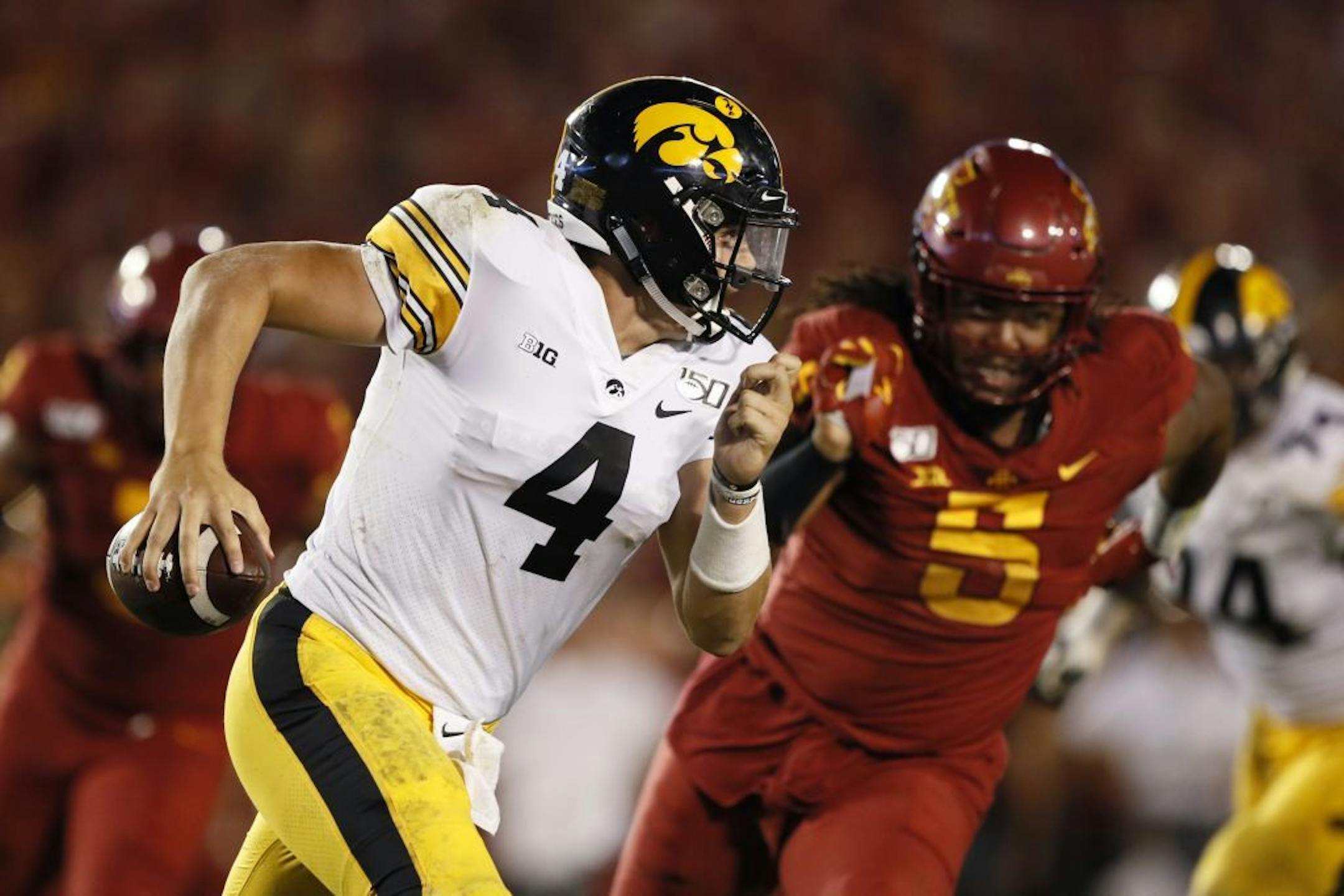 Iowa quarterback Nate Stanley runs from Iowa State defensive end Eyioma Uwazurike, right, during the second half of an NCAA college football game, Saturday, Sept. 14, 2019, in Ames, Iowa. Iowa won 18-17.