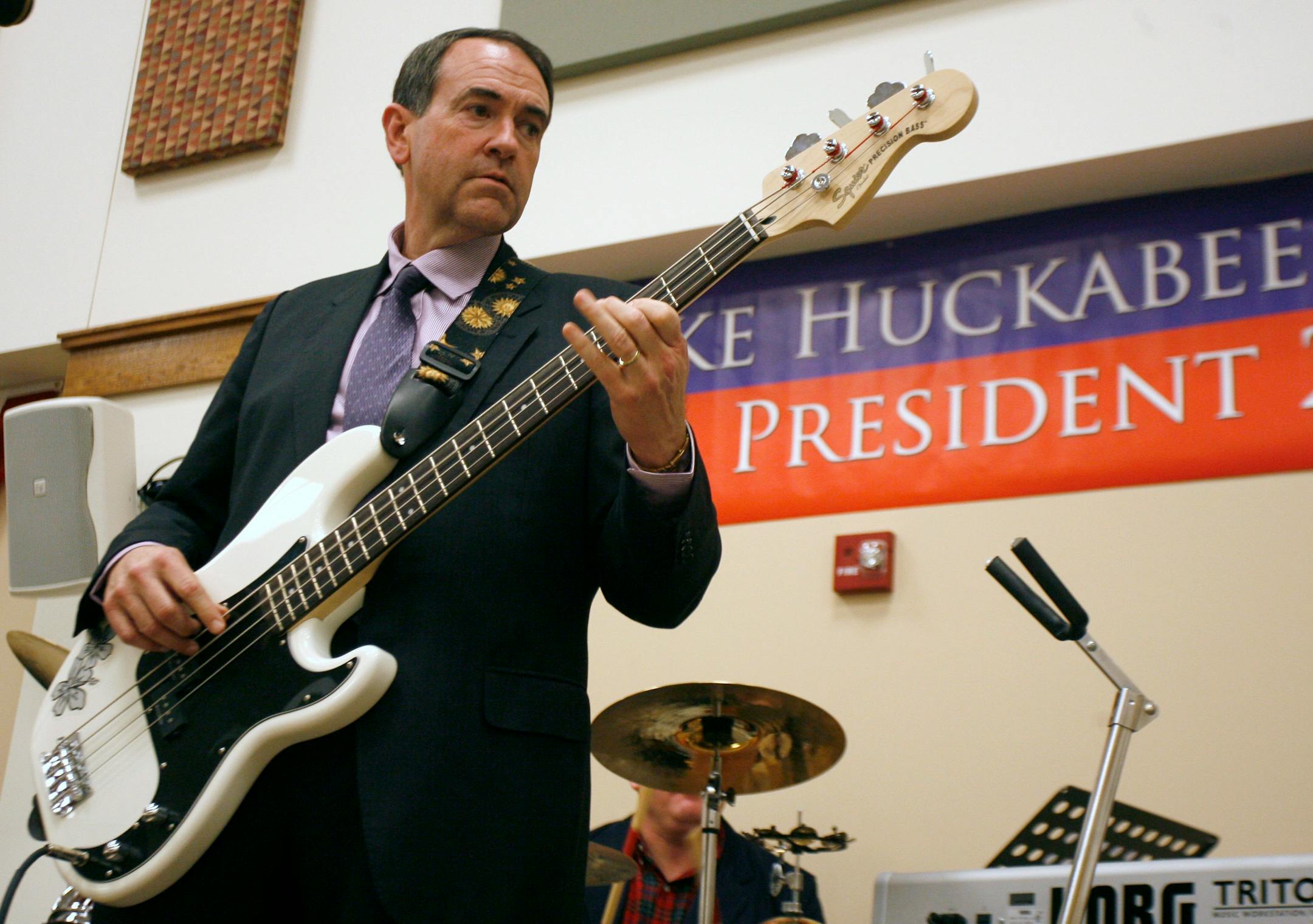 Republican presidential hopeful, former Arkansas Gov. Mike Huckabee plays a bass guitar with the band during a rally at the Mars Hill Academy Christian School Monday, Nov. 19, 2007, in Mason, Ohio.