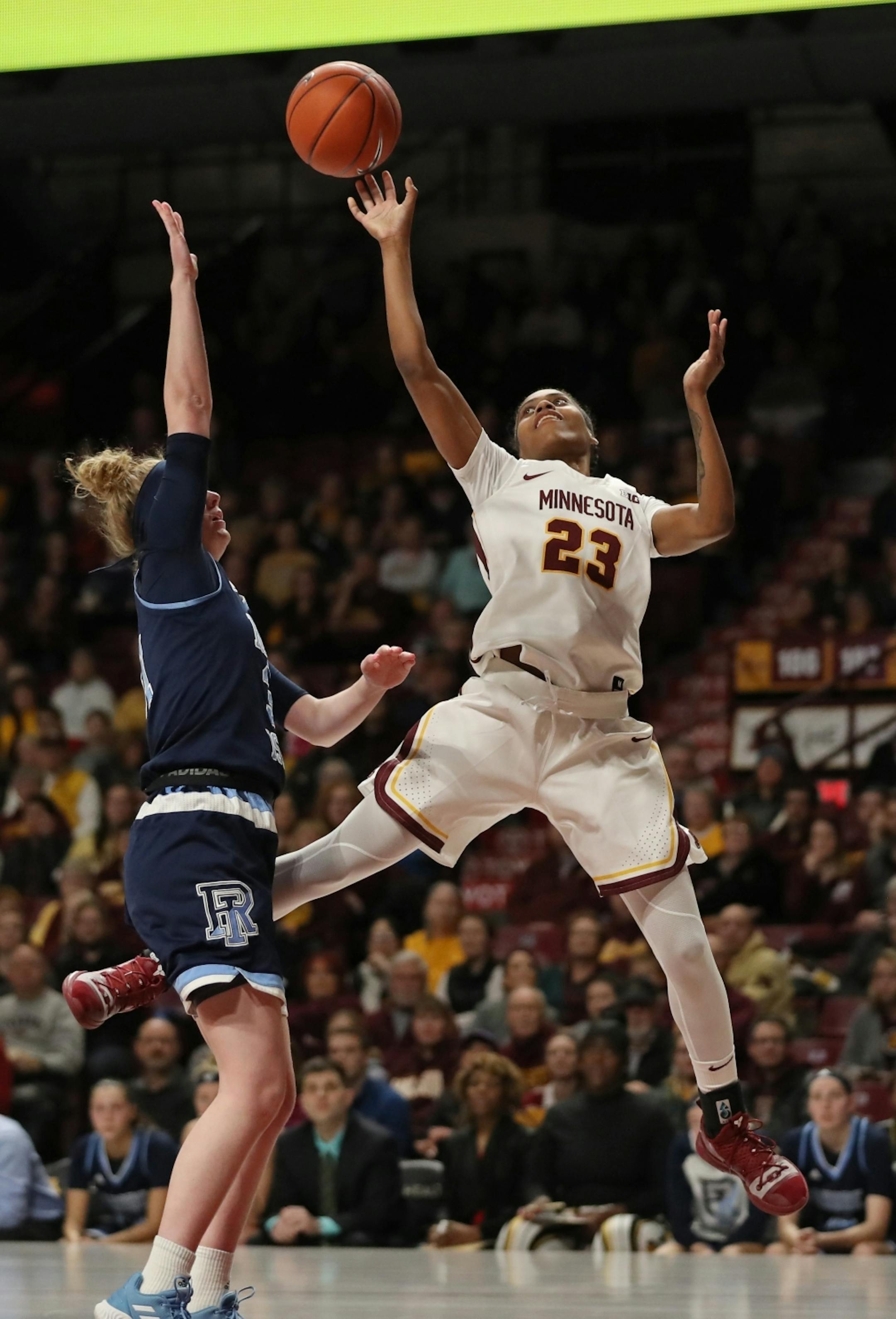 Minnesota Gophers guard Kenisha Bell (23) dodged past Rhode Island Rams guard Abby Streeter (31) for a layup in the first half.
