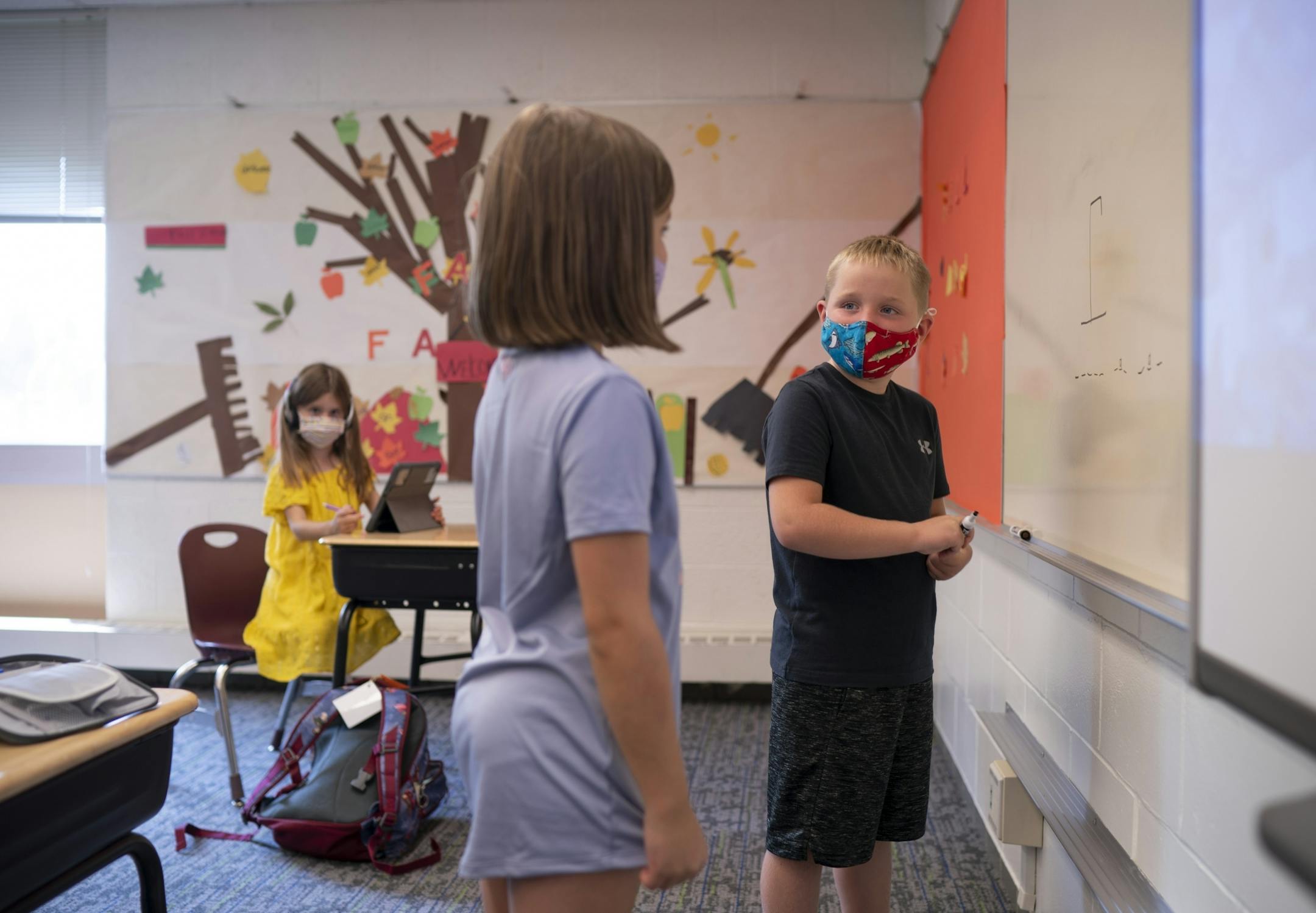 Two second grade kids who'd finished their classwork played a game of hangman before joining other in-school daycare kids for supervision by YMCA staffers.