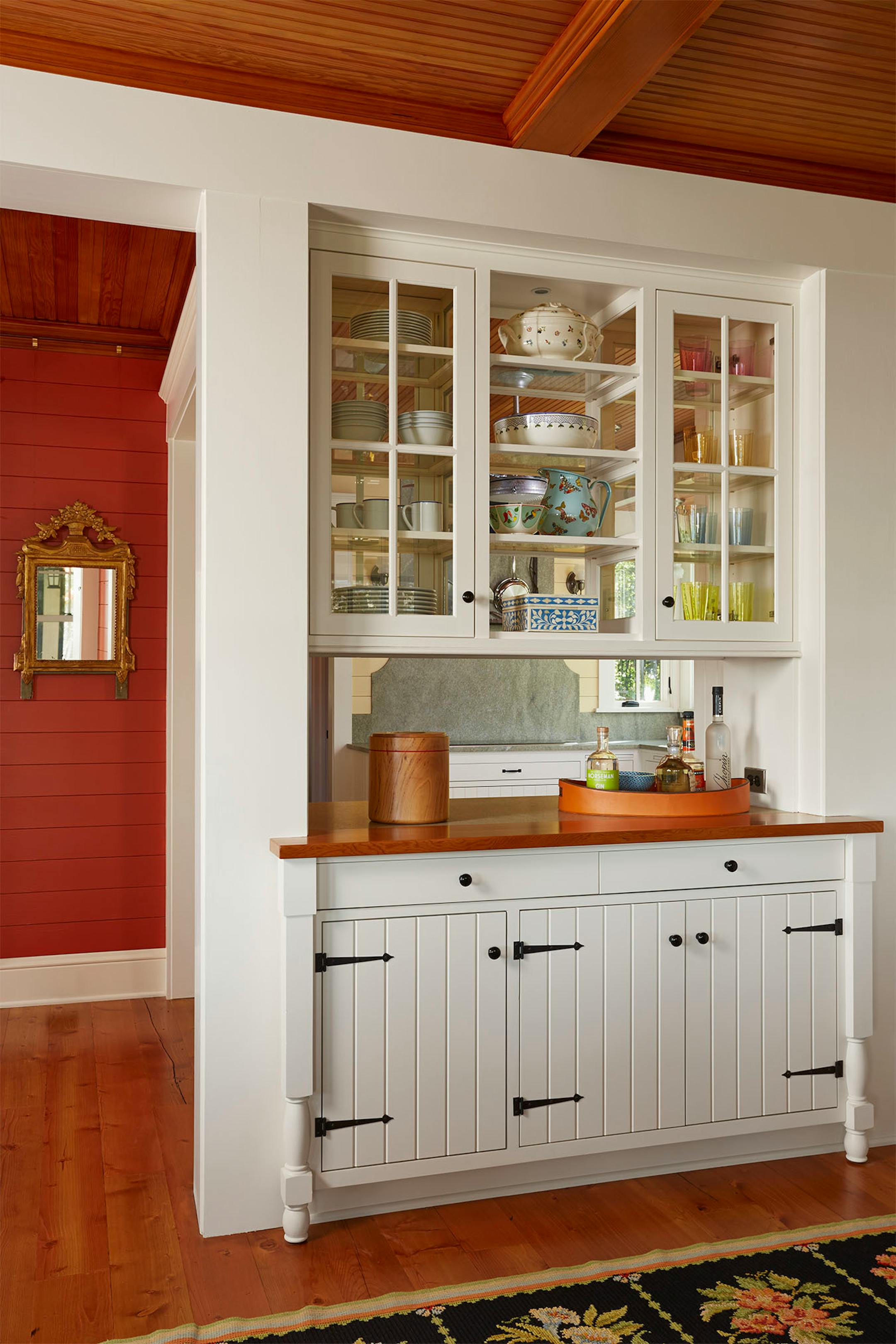 A built-in pass-through, with glass-front cabinets, between the kitchen and dining room.