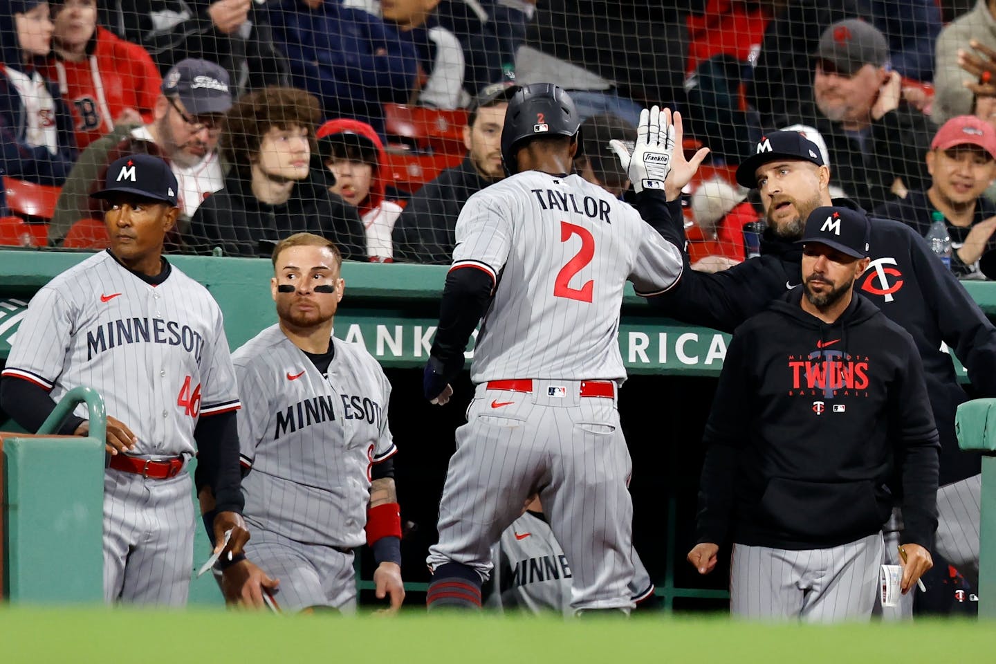 Minnesota Twins' Michael A. Taylor (2) celebrates after scoring on a sacrifice fly by Carlos Correa during the fifth inning of a baseball game against the Boston Red Sox, Tuesday, April 18, 2023, in Boston. (AP Photo/Michael Dwyer)