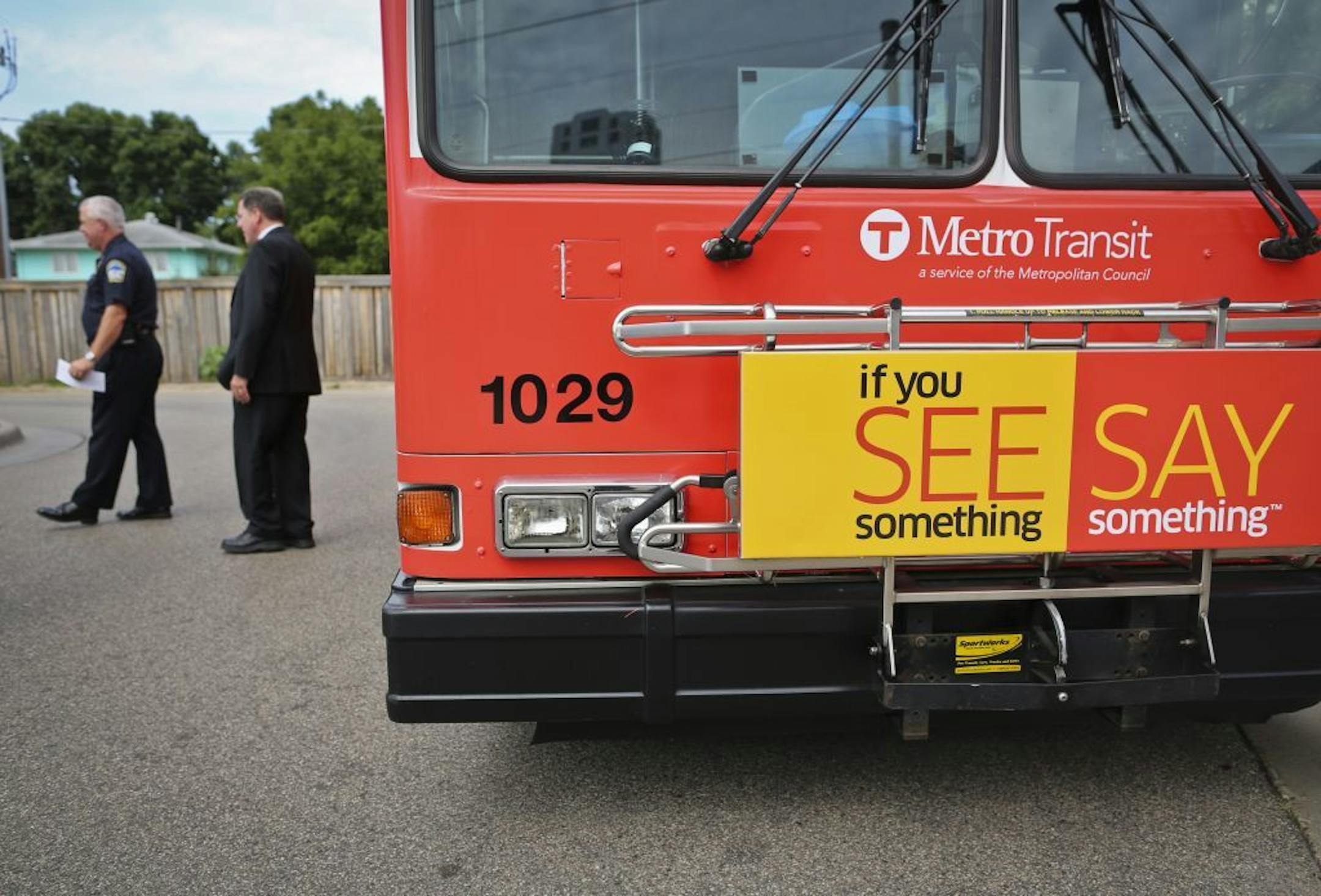 At left, A.J. Olson, acting Metro Transit police chief, stood with Bill Chandler, branch director of the Minnesota Department of Public Safety Division of Homeland Security and Emergency Management, next to a bus with signs encouraging the public to pay attention for suspicious activity and report it to local authorities, during a press conference at a Light Rail station on Hiawatha on Friday, August 3, 2012 in Minneapolis, Minn. The campaign is putting the logo "See something, say something," o