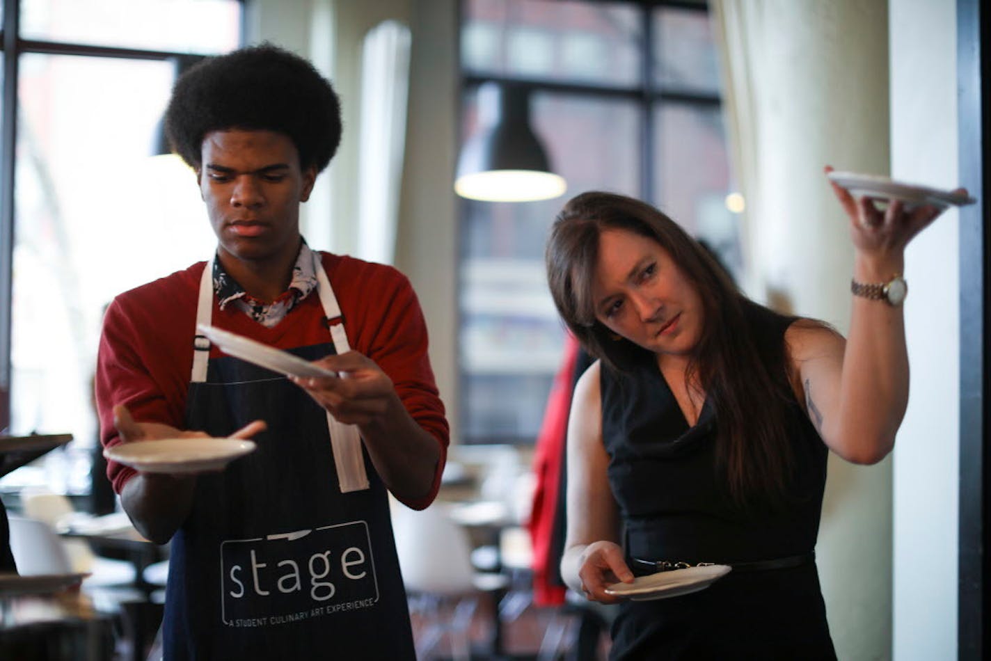 Laurel Elm, general manager at Saint Dinette, taught Robyn Nelson the proper way to carry multiple plates.