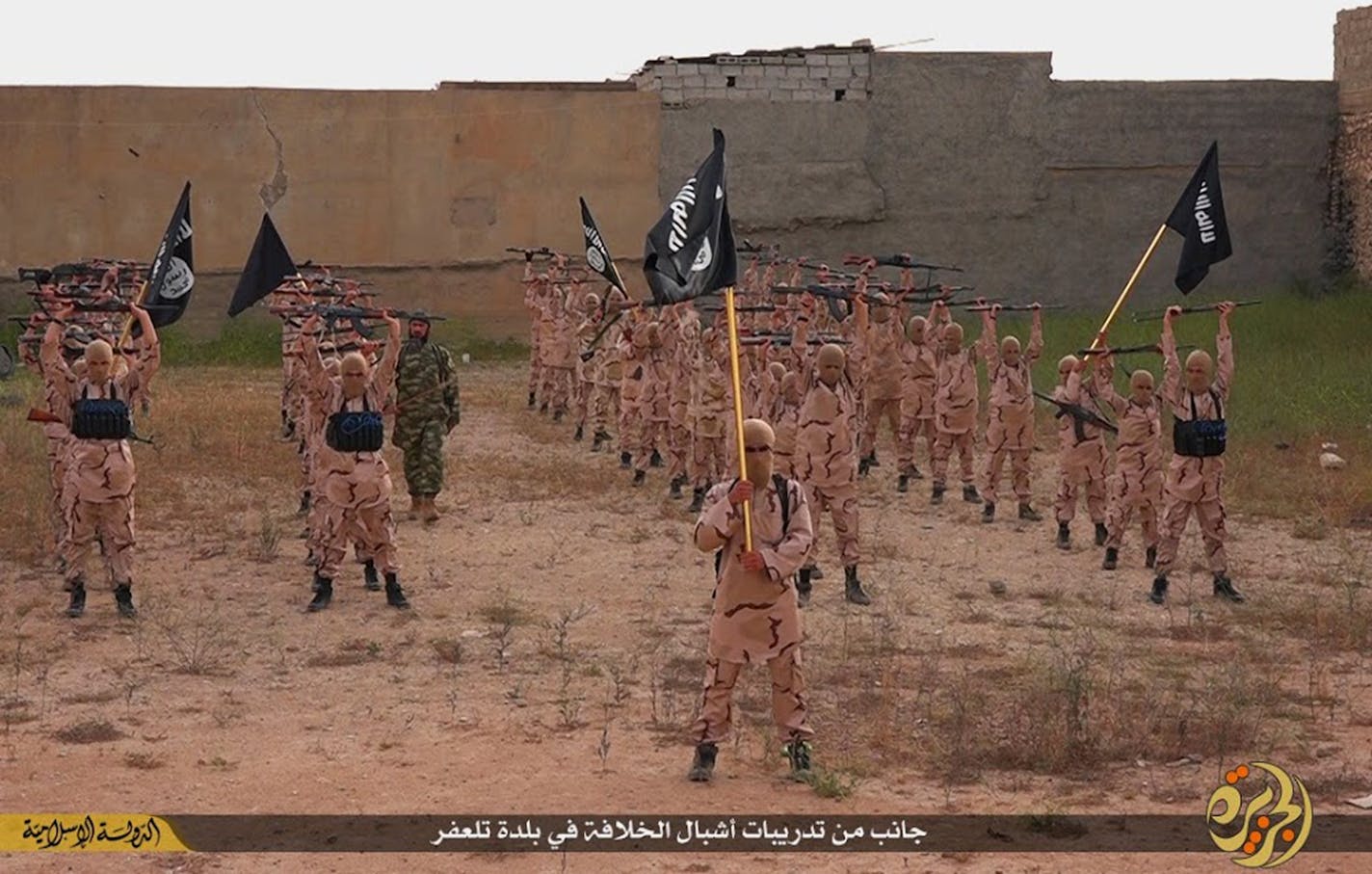 In this photo released on April 25, 2015, by a militant website, young boys known as the "caliphate cubs" hold rifles and Islamic State group flags as they exercise at a training camp in Tal Afar, near Mosul, northern Iraq. Using various methods, including cash rewards, intimidation and indoctrination, IS fighters have made children and teens a focus of their recruitment efforts, running schools, orphanages and training camps.