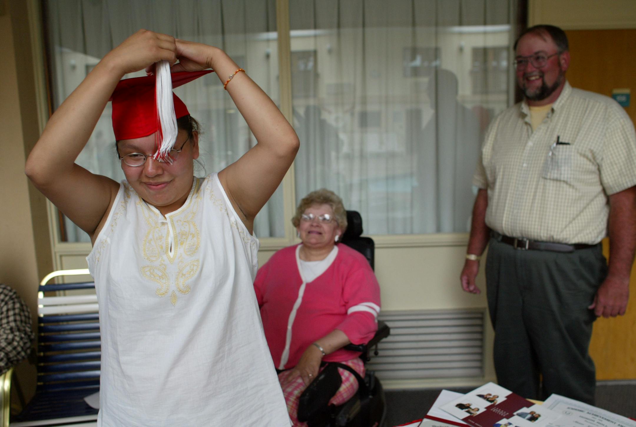 Sierra Goodman adjusted her graduation cap as Carol and Gene Campbell looked on during a graduation party in 2003. Carol and Sierra went to Washington last week to lobby Congress to modify the Indian Child Welfare Act.
