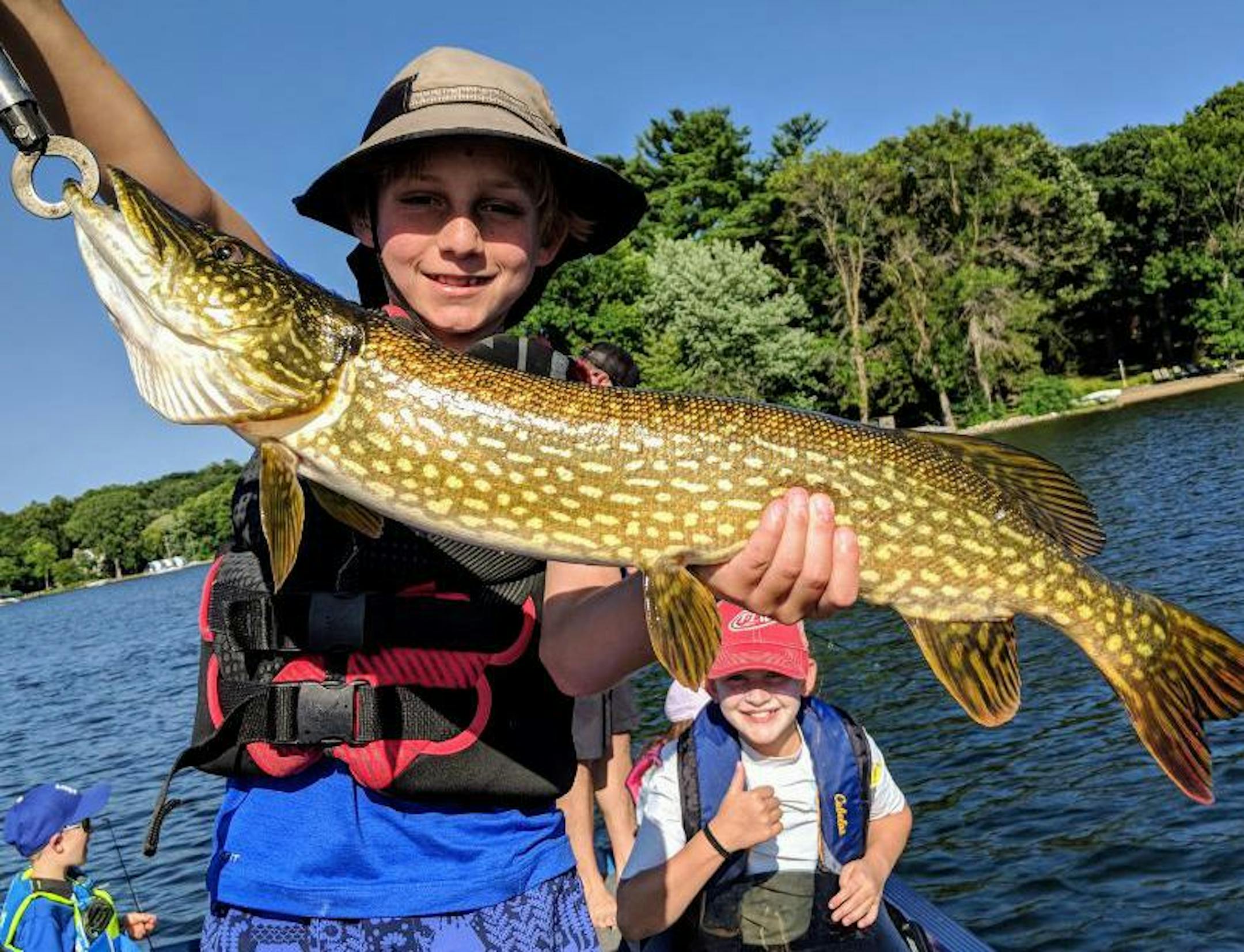 Drew Conzemius, holding fish, and Ella Ringer, lower right.