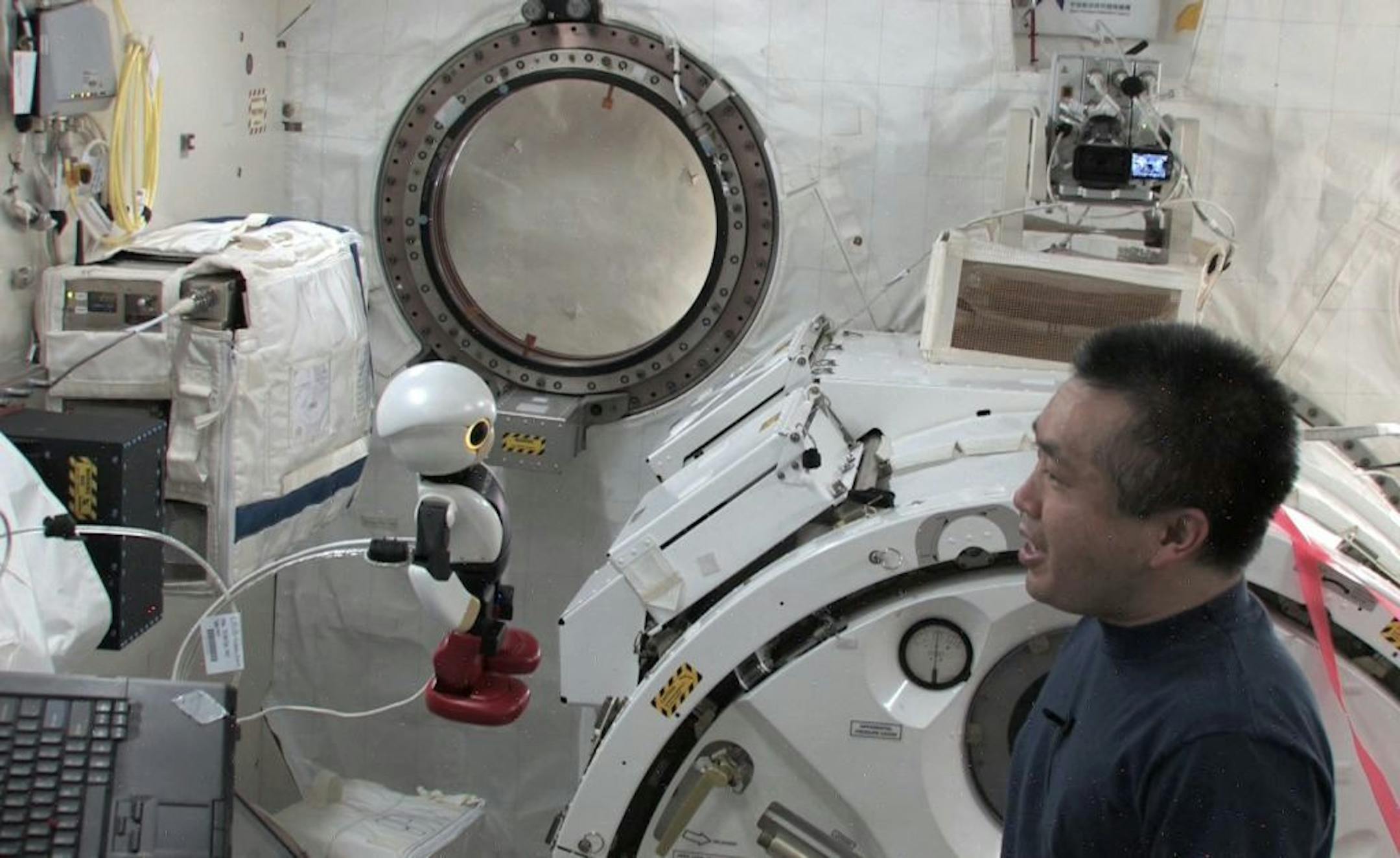 In this undated image made from video released by KIBO ROBOT PROJECT in Tokyo Tuesday, May 13, 2014, Japanese astronaut Koichi Wakata speaks to Kirobo, a talking humanoid robot, on board the International Space Station (ISS).