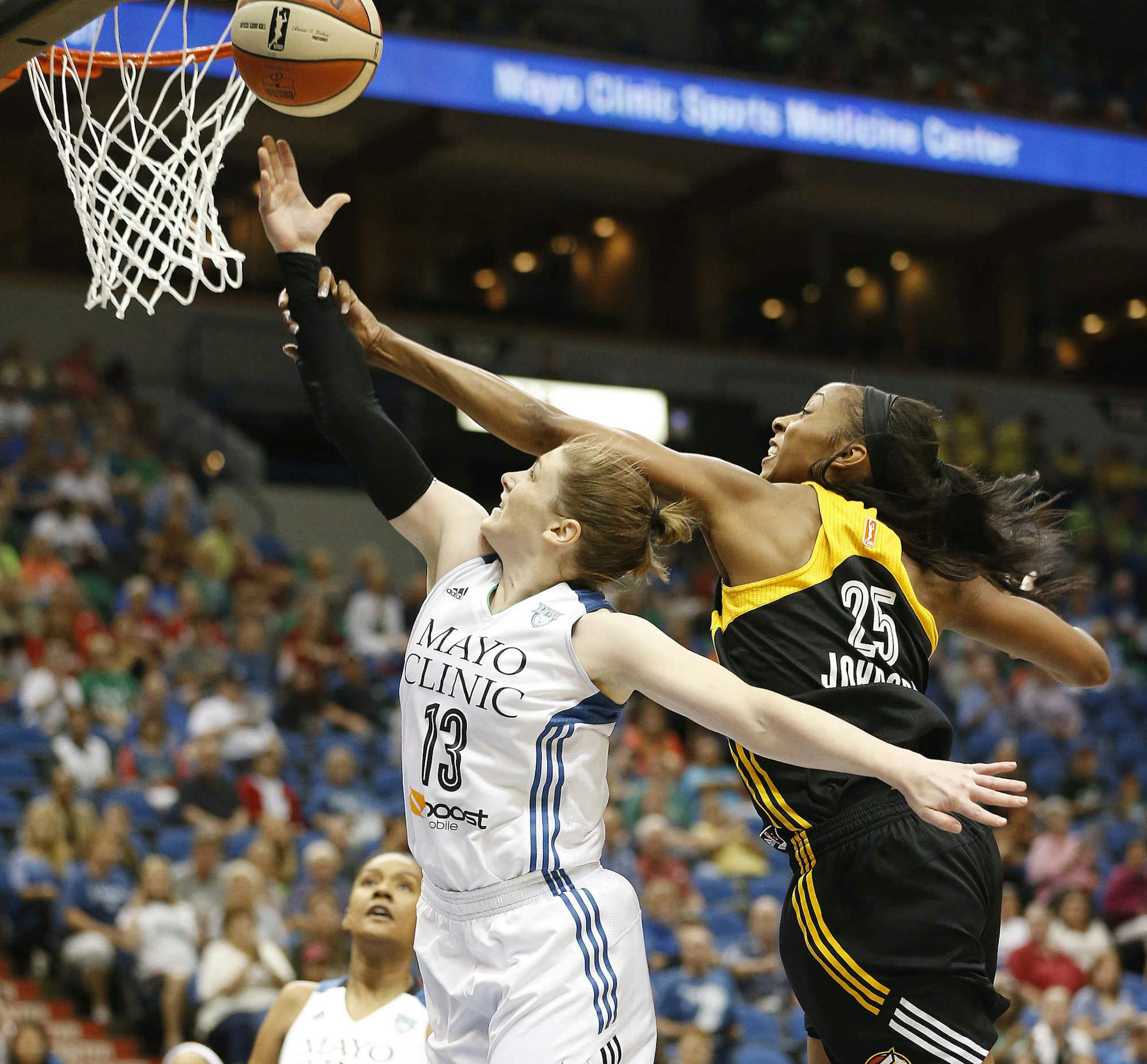 Minnesota Lynx guard Lindsay Whalen (13) is fouled by Tulsa Shock forward Glory Johnson (25) as she pushes up to shoot the ball in the first half of a WNBA basketball game, Wednesday, July 16, 2014, in Minneapolis. (AP Photo/Stacy Bengs)